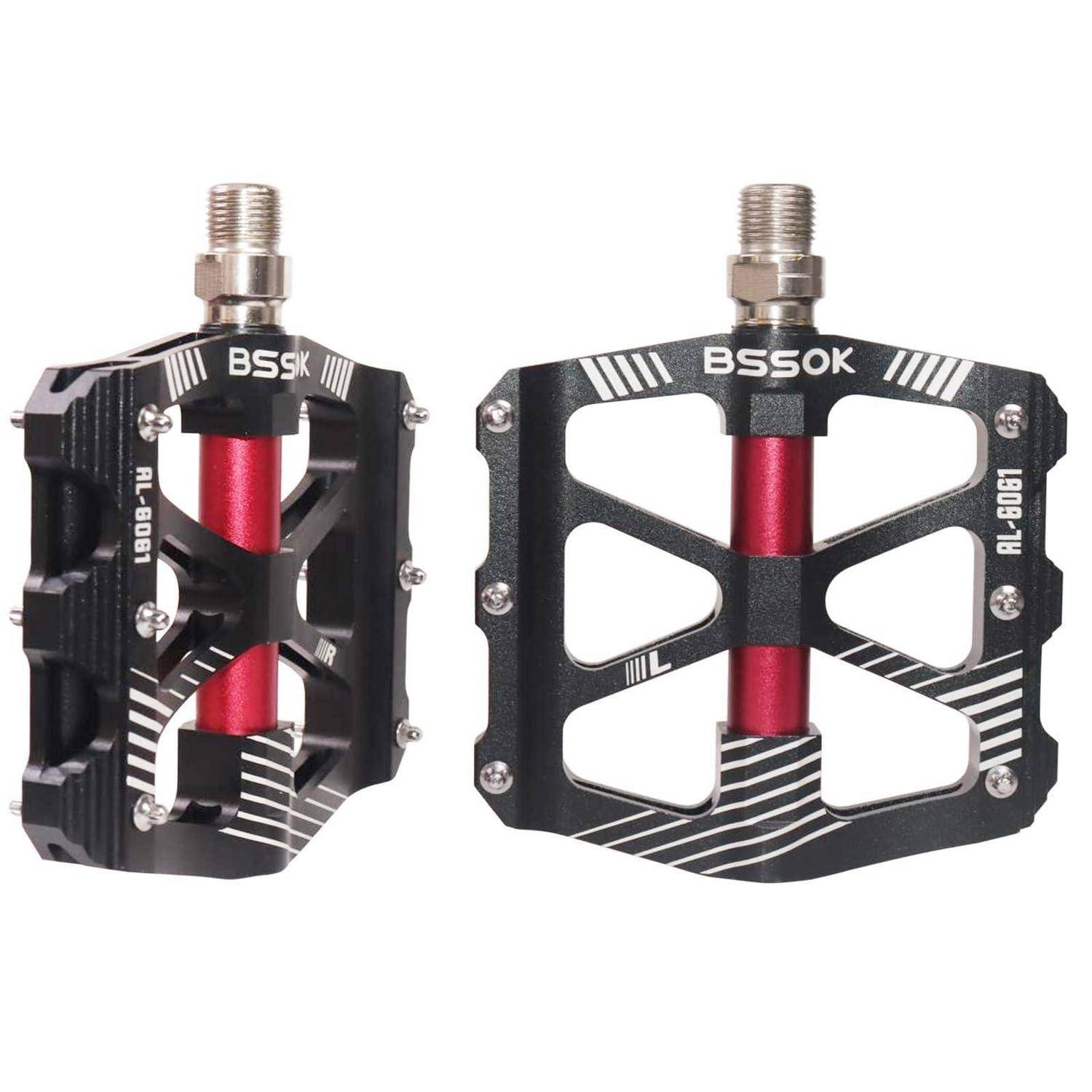 Paar schwarzer BSSK-Fahrradpedale mit roten mittleren Spindeln, shown in front and side views on a white background.