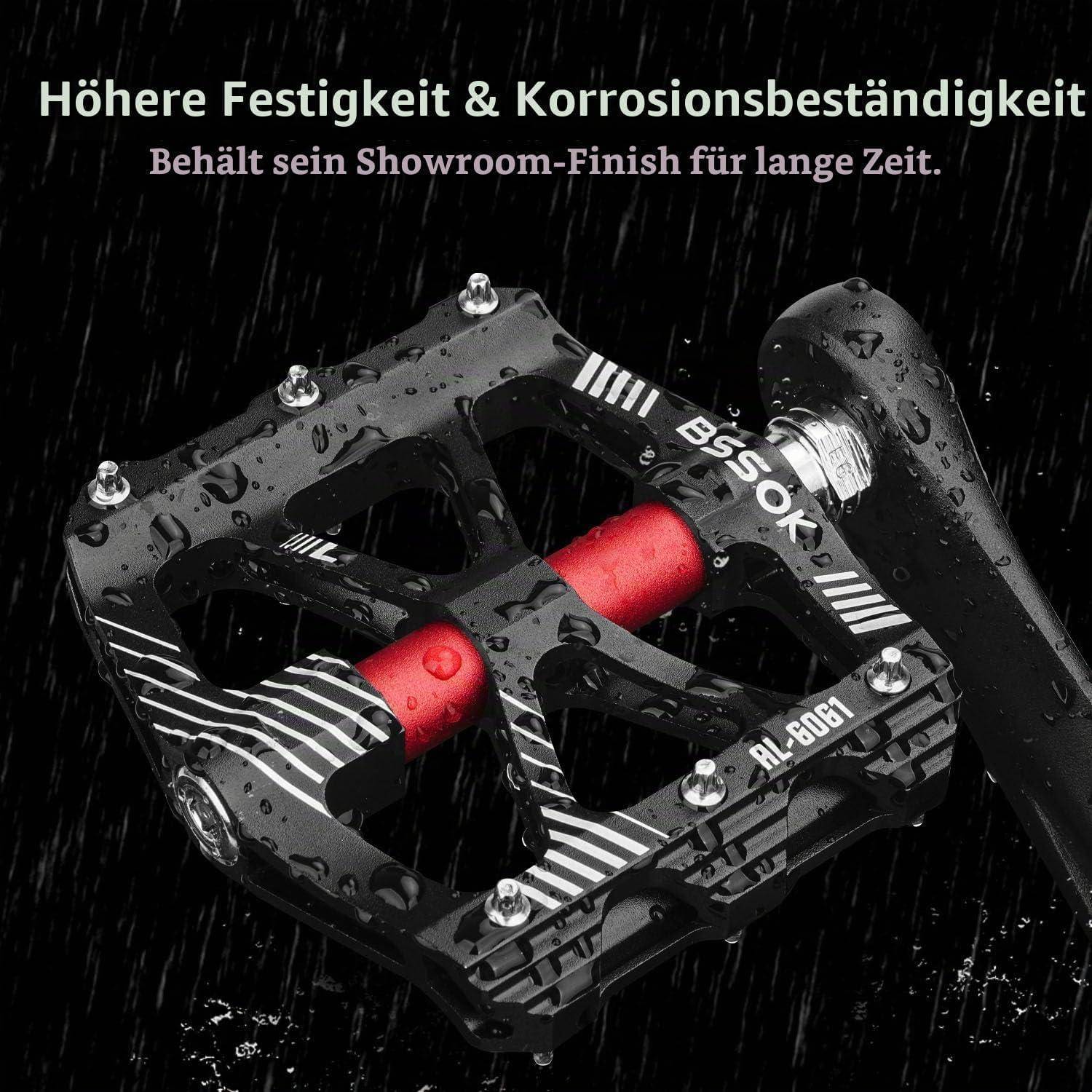 Schwarzes BSS-0K-Fahrradpedal mit roten Achsen, gezeigt im Regen, bewirbt höhere Festigkeit und Korrosionsbeständigkeit bei Beibehaltung einer ausstellungsreifen Oberfläche.