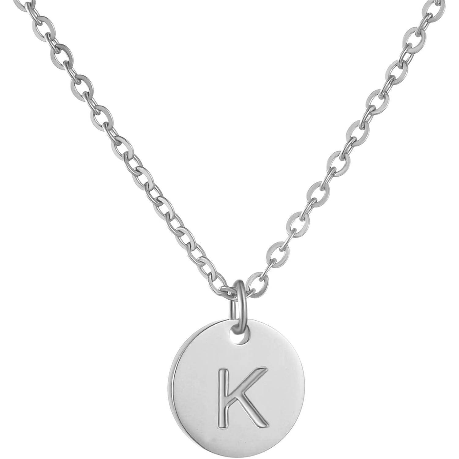 Silberkettenhals mit rundem Anhänger, graviert mit dem Buchstaben 'K' auf weißem Hintergrund.