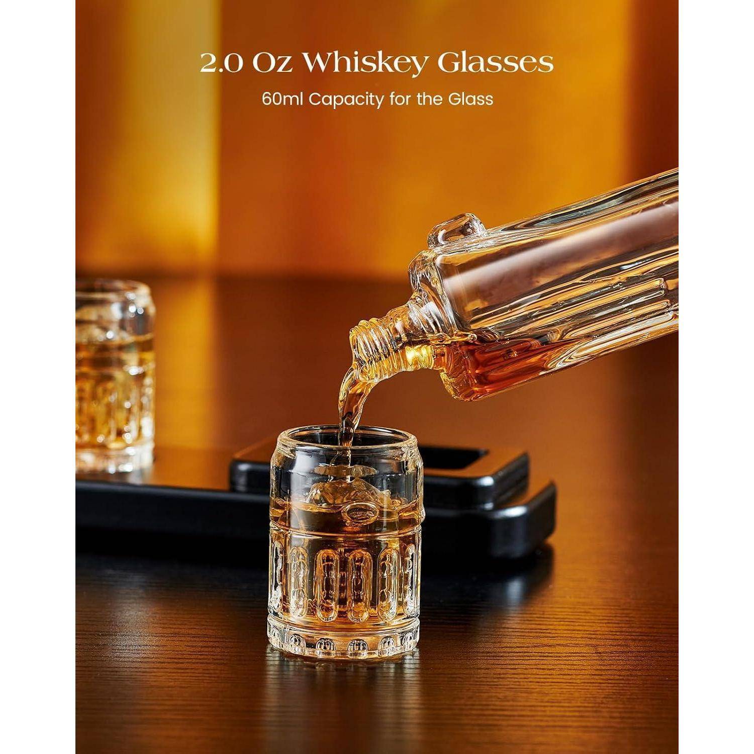 Whiskey wird aus einem Glaskrug in ein kleines Glas gegossen; der Text lautet „2,0 Oz Whiskey-Gläser