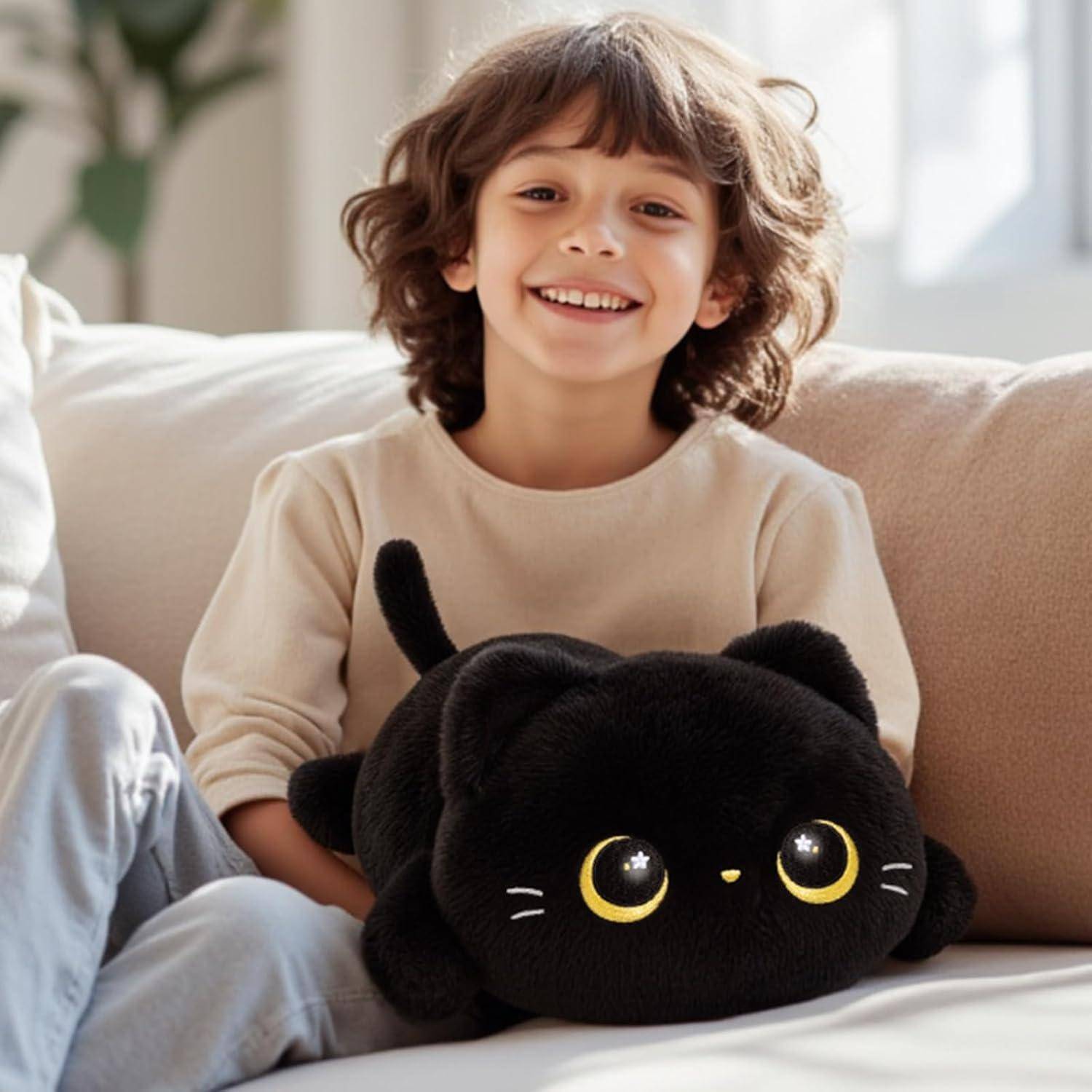 Lachendes Kind sitzt auf einem Sofa und hält eine schwarze Plüschkatze mit großen gelben Augen in einem hellen Wohnzimmer.