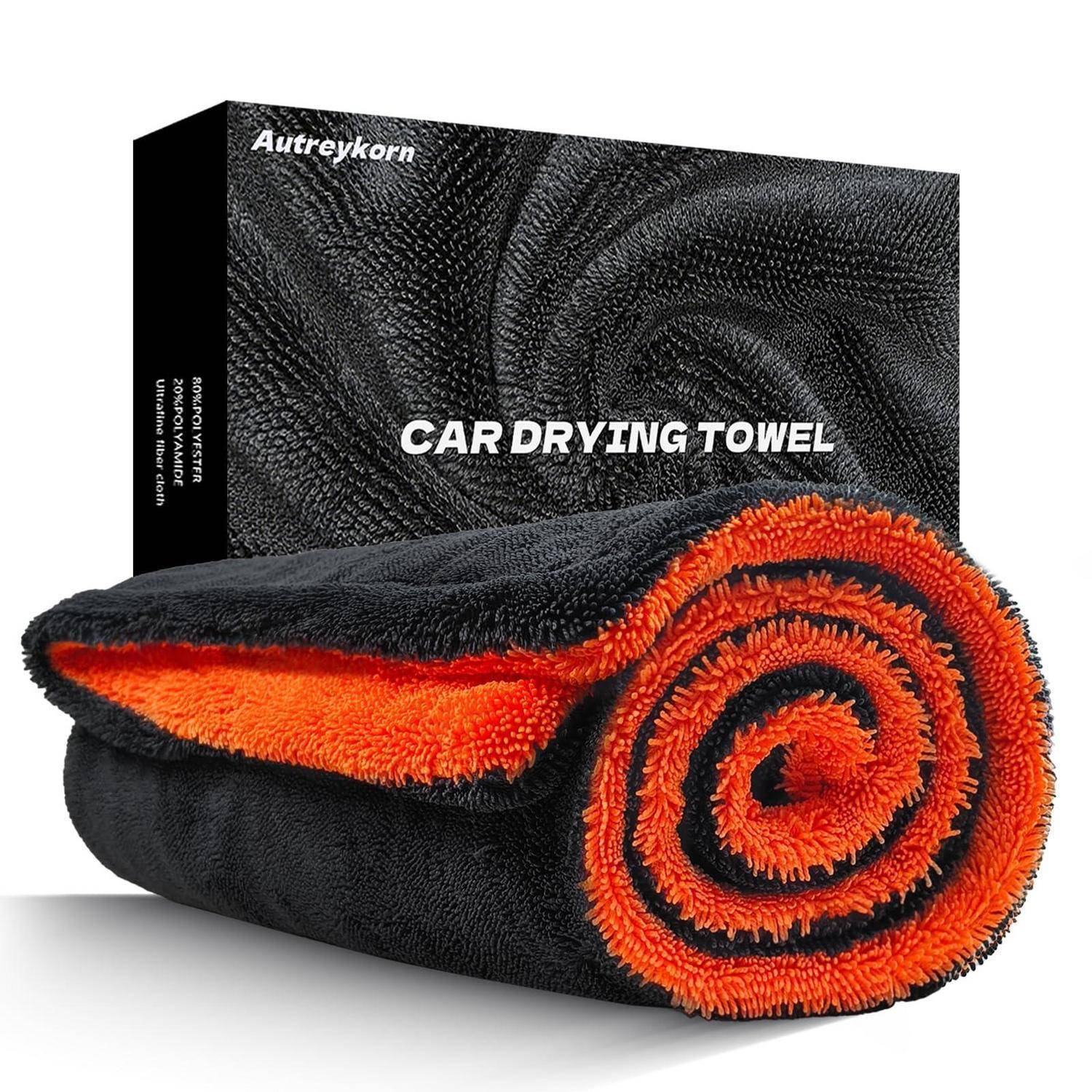 Gerolltes schwarz-oranges Auto-Trockentuch vor seiner Produktbox mit der Aufschrift „CAR DRYING TOWEL
