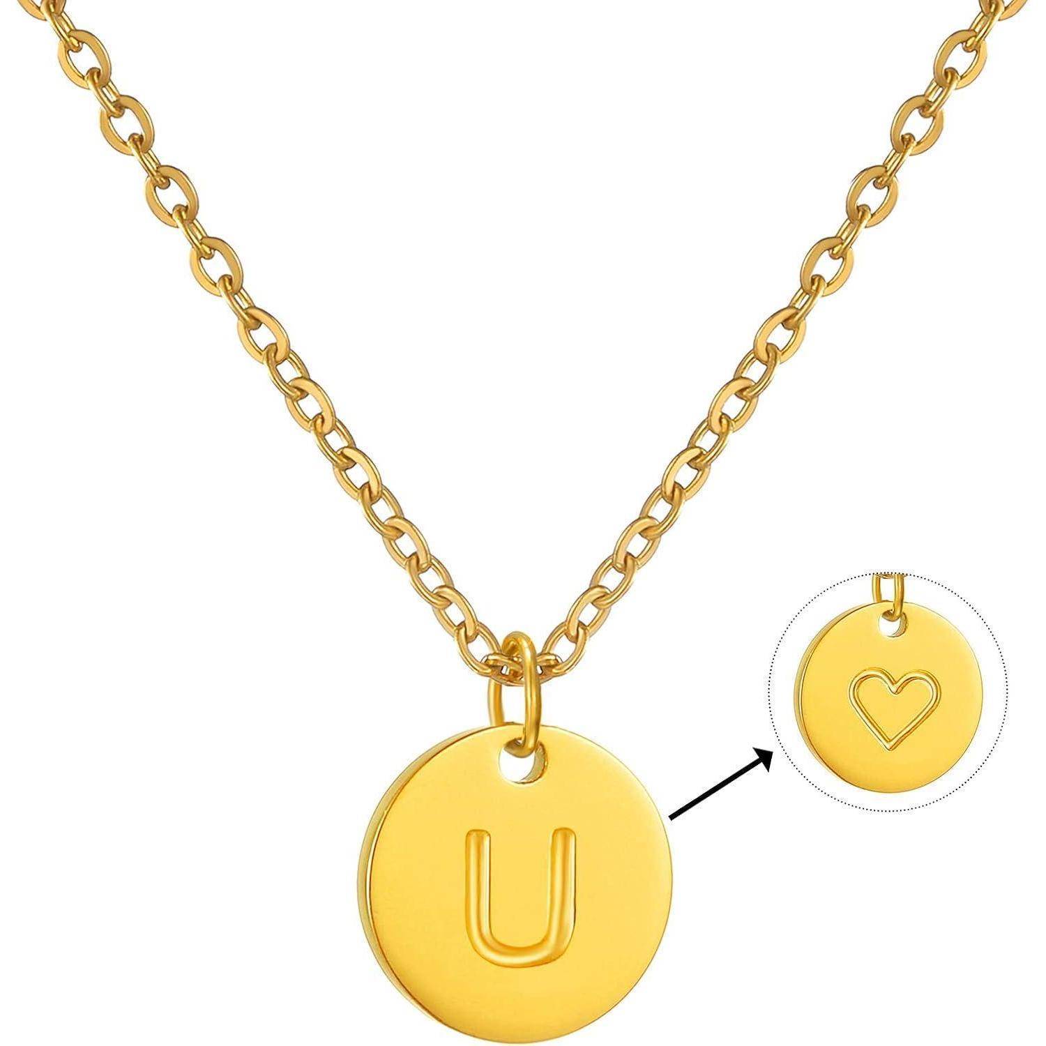 Goldkettenhalsband mit rundem Anhänger, der mit einem großen U graviert ist; die Detailaufnahme zeigt die Rückseite des Anhängers mit einem ausgeschnittenen Herzmotiv.