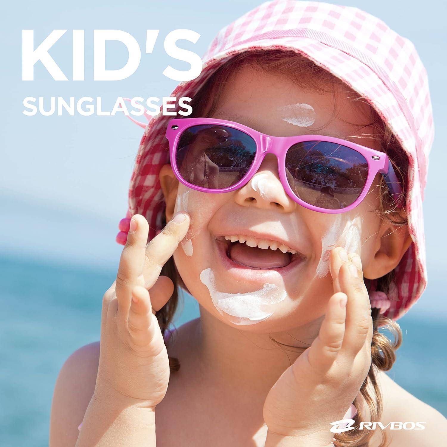 Kind trägt violette Sonnenbrillen und einen rosa Sonnenhut am Strand, mit dem Text „KINDERSONNENBRILLEN" in der Ecke.