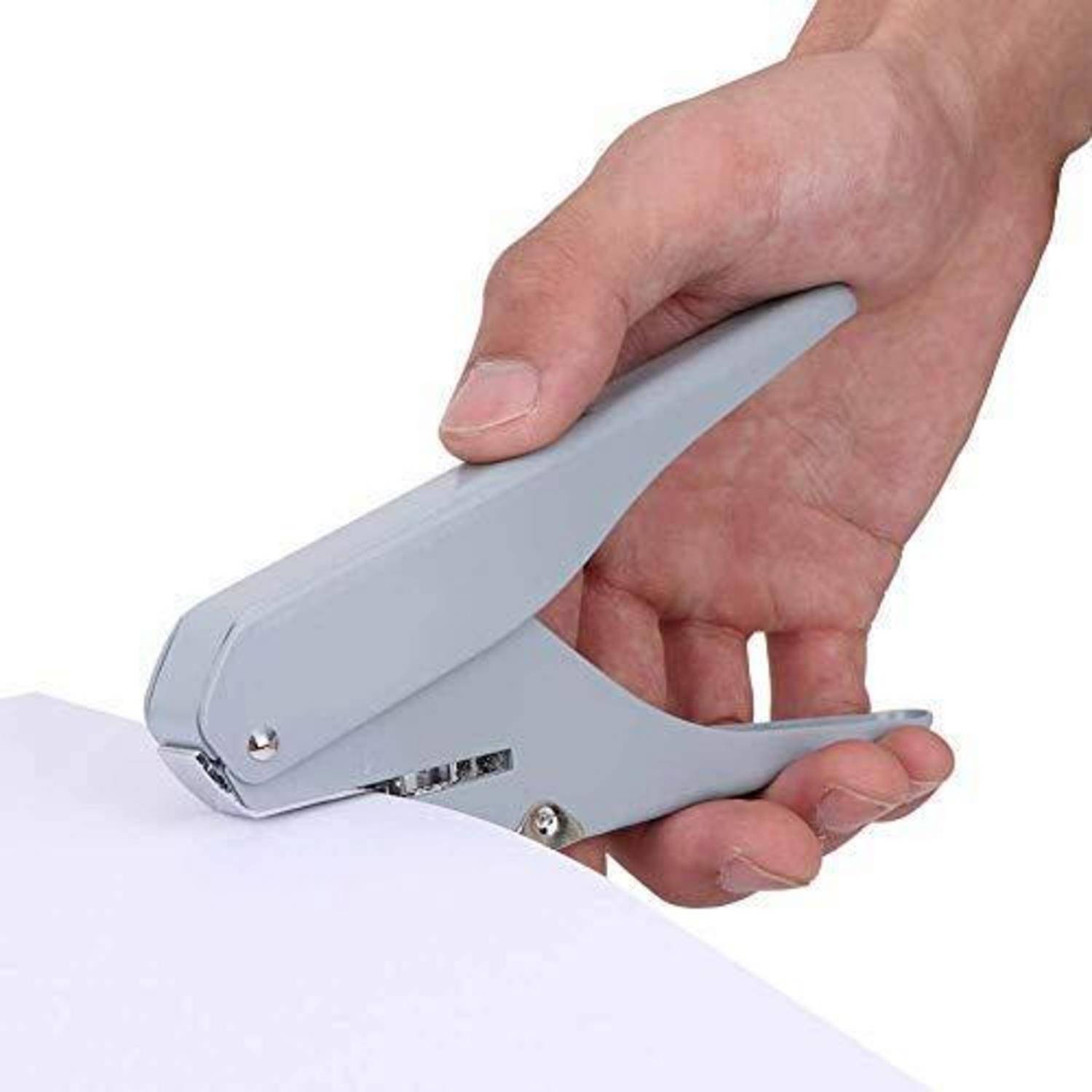 Eine Hand, die einen grauen Hefter benutzt, um einen Stapel weißes Papier zu heften.