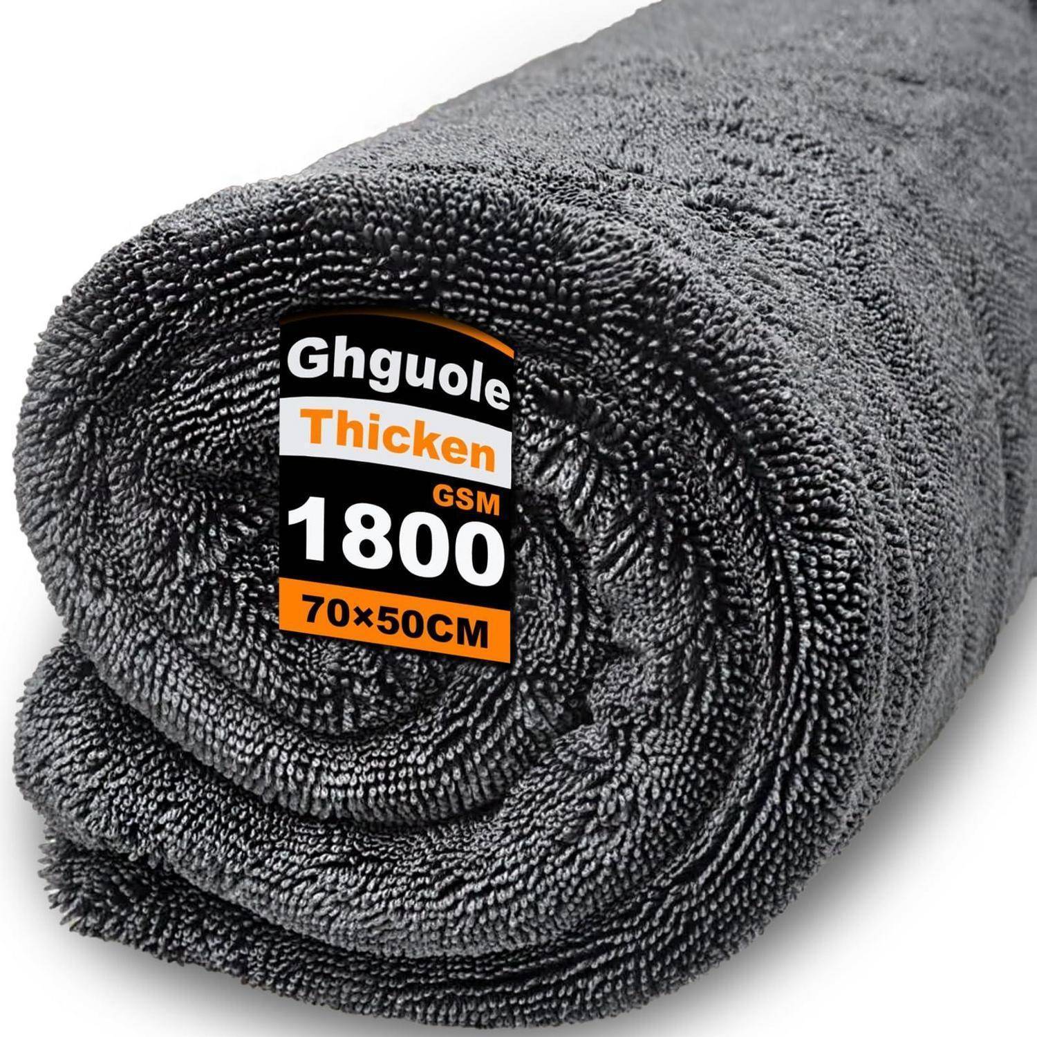 Gerolltes grau Mikrofasertuch mit Etikett mit den Aufschriften „Ghquole