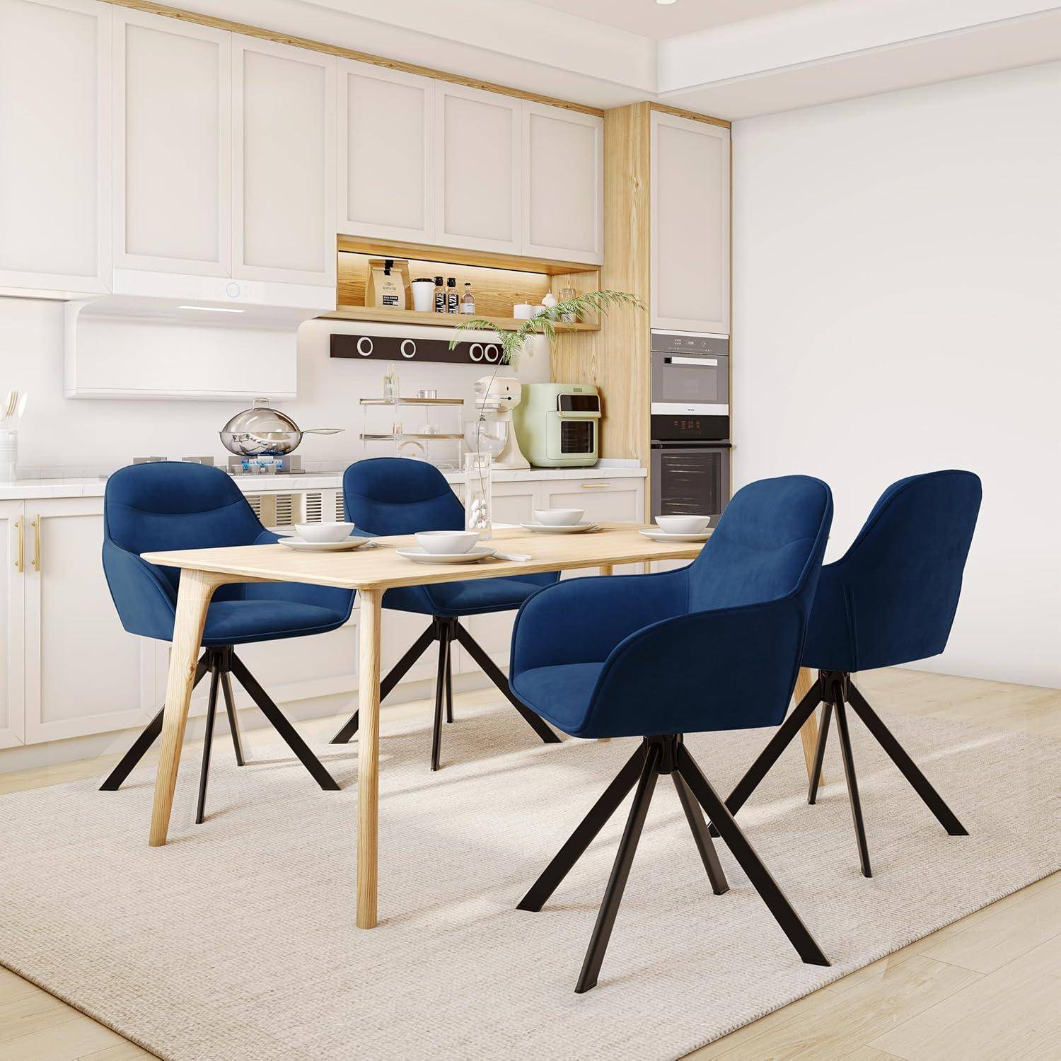 Moderner Essbereich mit einem Tisch aus hellem Holz und vier blau gepolsterten Stühlen in einer hellen weißen Küche.