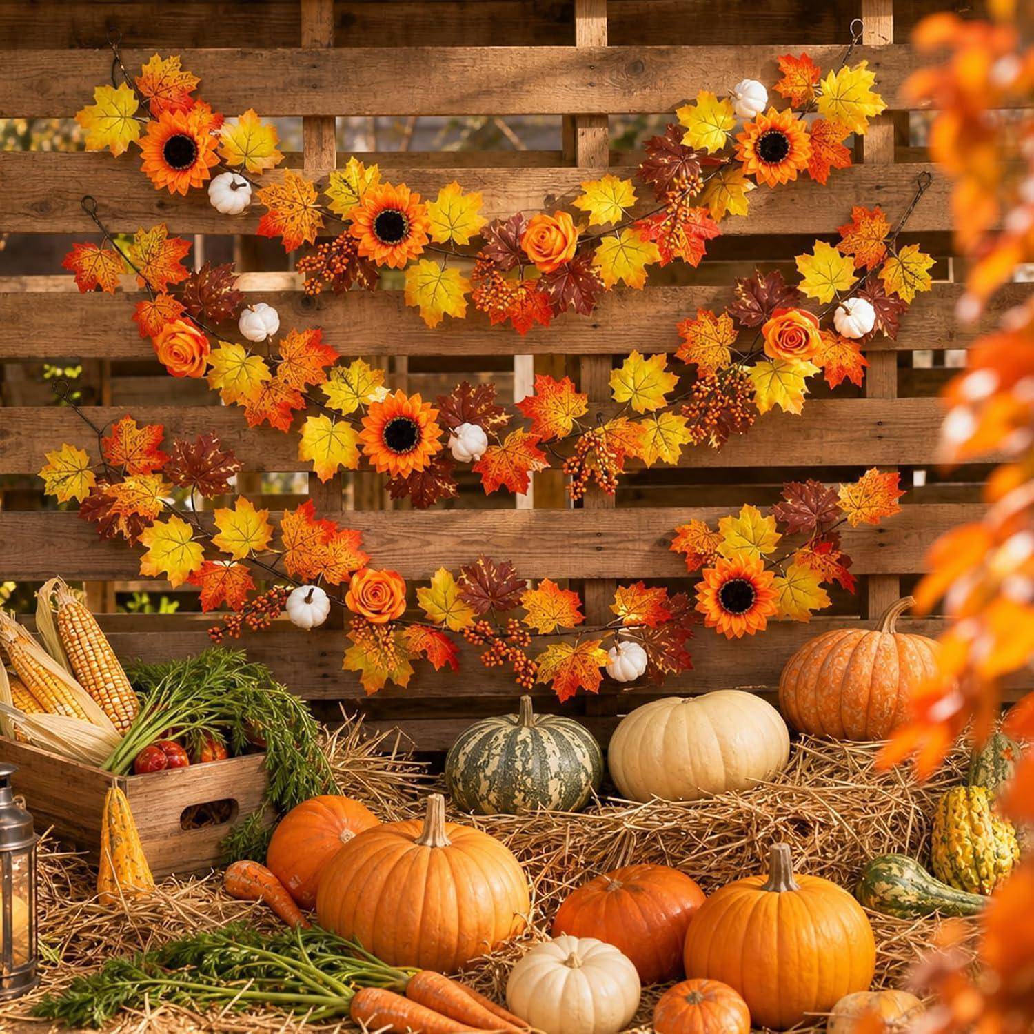 Herbstliche Erntepräsentation mit Kürbissen, Zierkürbissen, Mais, Heuballen und Herbstlaub-Girlanden auf einem Holzhintergrund.