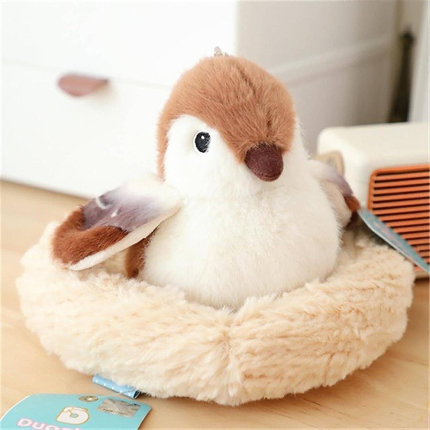 Plüsch-Vogel-Spielzeug mit braunem und weißem Fell sitzt in einem flauschigen cremefarbenen Nest auf einer Tischplatte, mit einem Produktetikett angebracht.