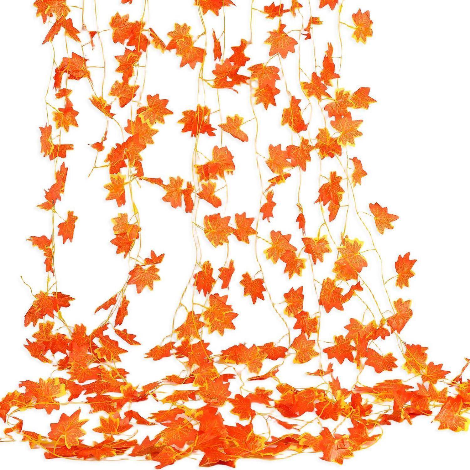 Orange-farbige Herbstblatt-Girlanden-Stränge, die hängen und sich am Boden auf weißem Hintergrund sammeln