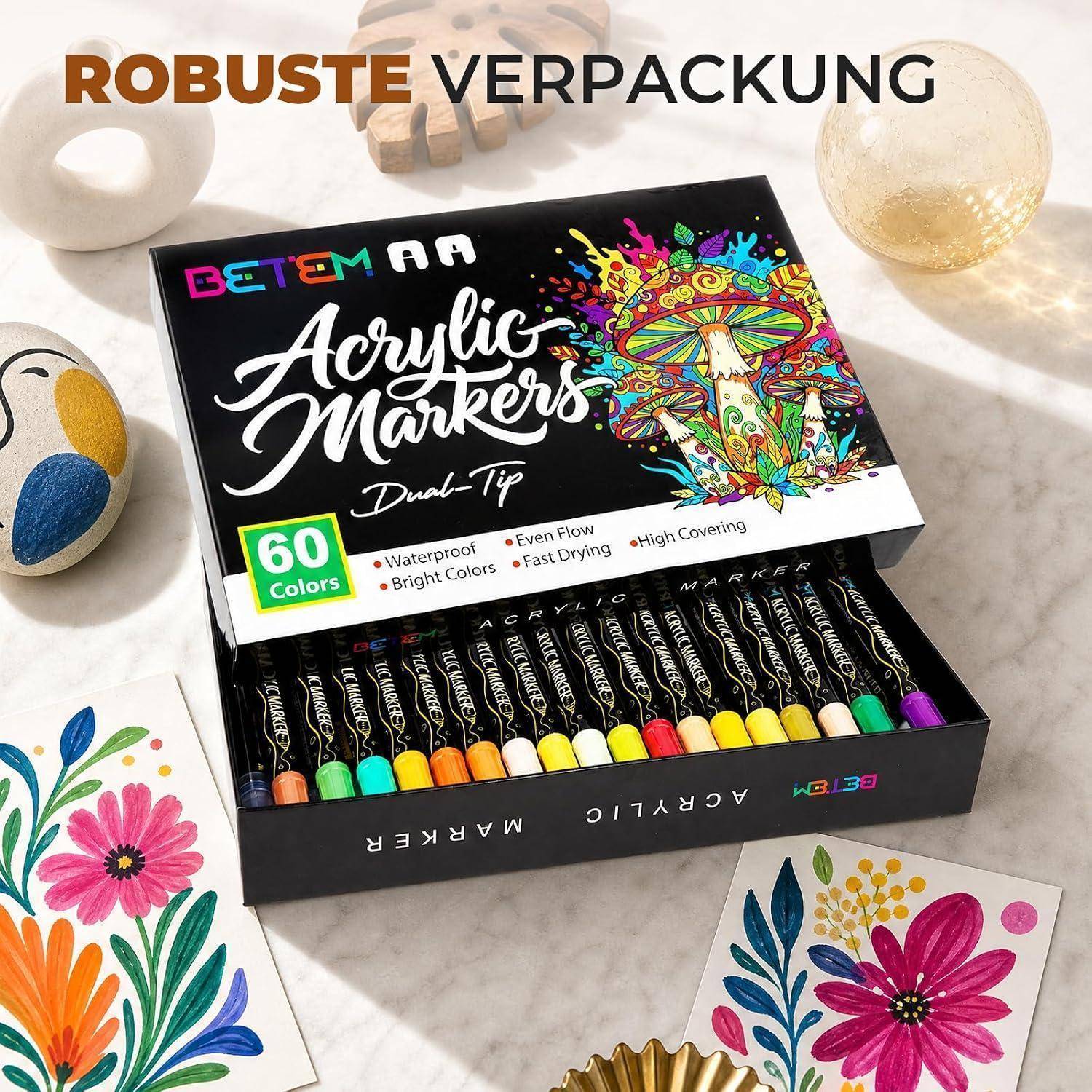 Offene Schachtel BETEM Acrylmarker mit der Bezeichnung 60 Farben, zeigt farbenfrohe Doppelspitzen-Stifte und Beispiele von Blütenkunstwerk; Text sagt 'ROBUSTE VERPACKUNG'.