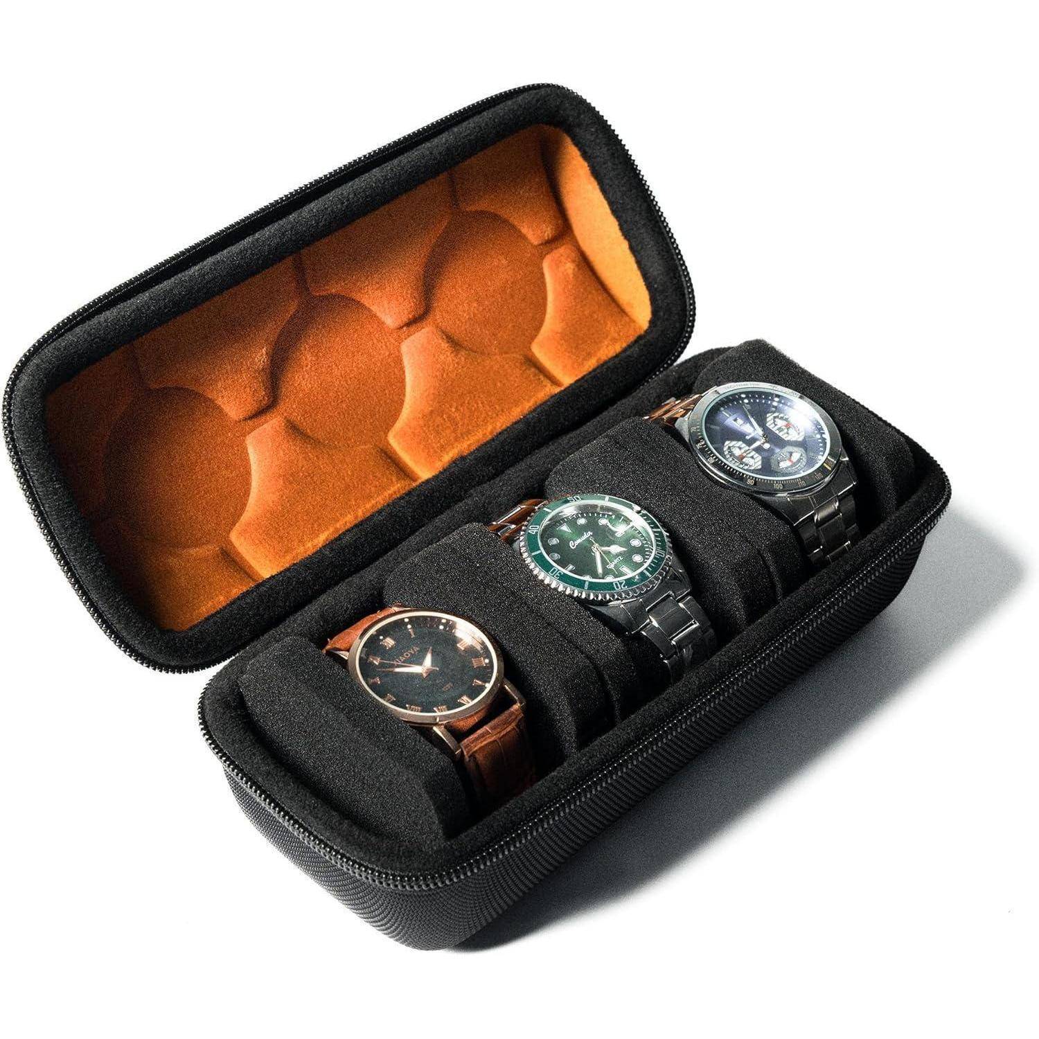 Offene schwarze Uhrentasche mit Reißverschluss und orange gepolstertem Deckel, mit drei Armbanduhren in Schaumstoffnischen.