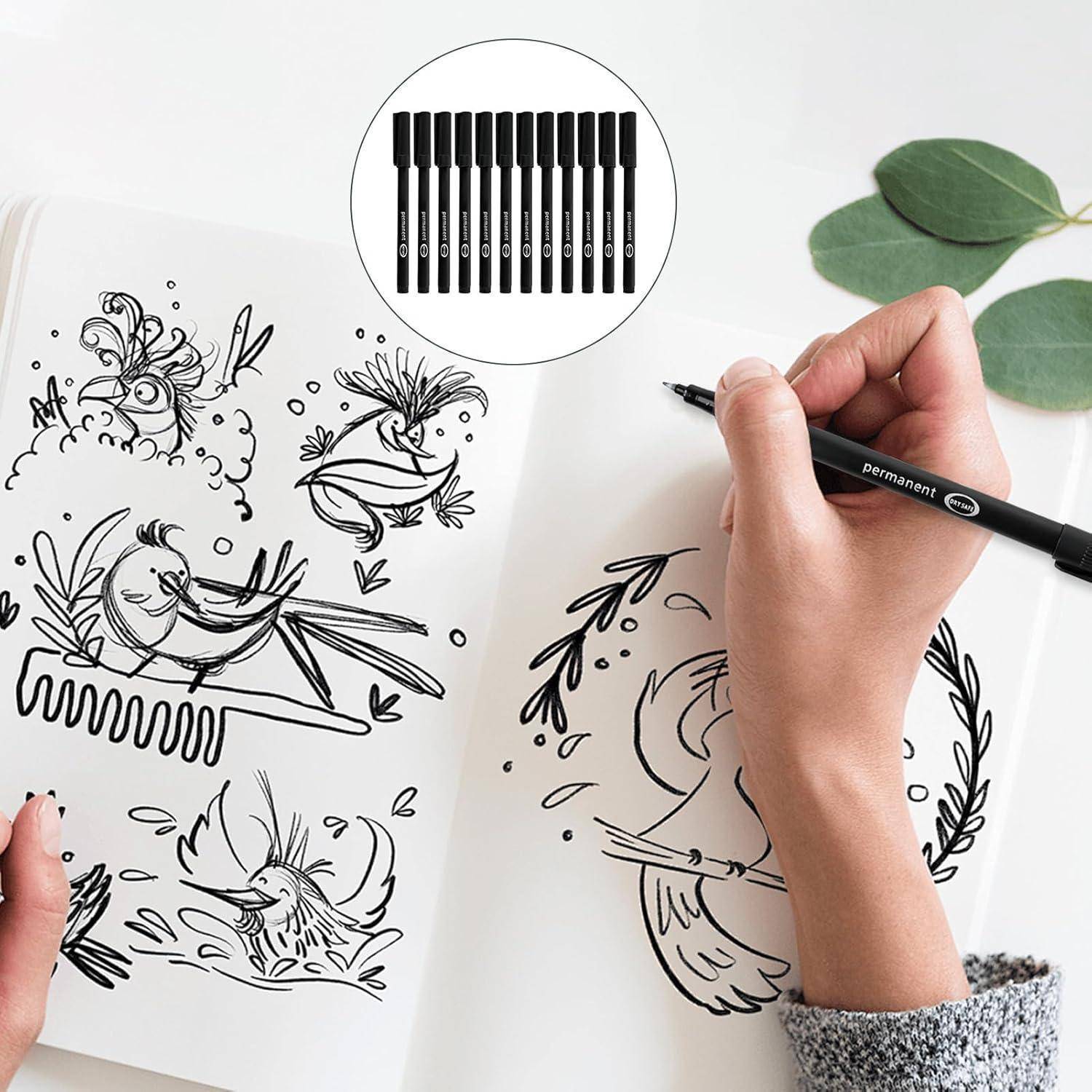 Hände, die Vogel- und Blumenzeichnungen in einem offenen Notizbuch mit einem schwarzen Permanentmarker skizzieren; die Vergrößerung zeigt eine Reihe von Markern.