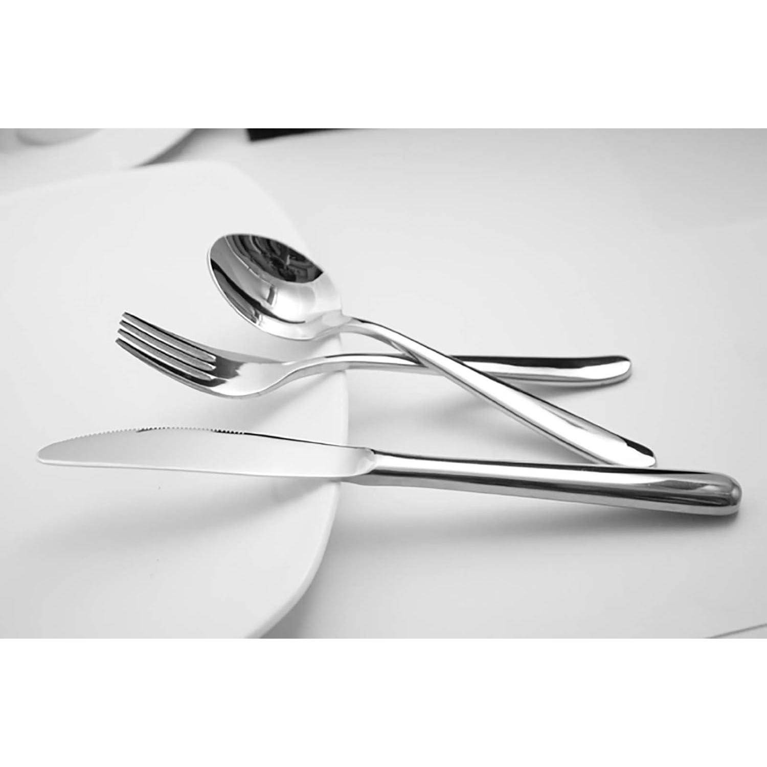 Eine Gabel, ein Löffel und ein Messer, arrangiert auf einem weißen Teller, zeigen ein einfaches Tischgedeck.