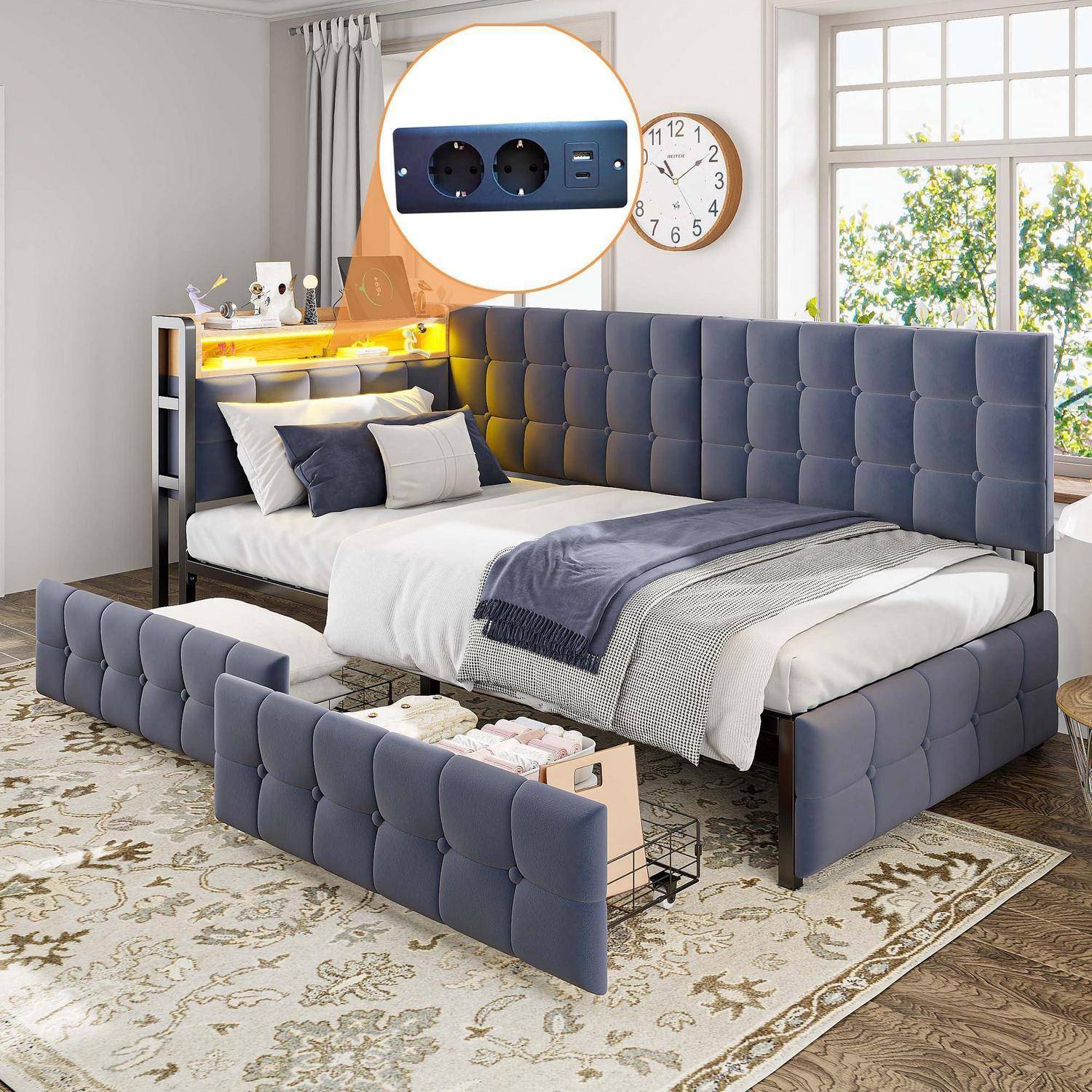 Blaugepolstertes Bett mit verstellbarer Seitengitterstange und eingebautem Stromanschluss, gezeigt in einem hellen Schlafzimmer mit weißer Bettwäsche und einem gemusterten Teppich.