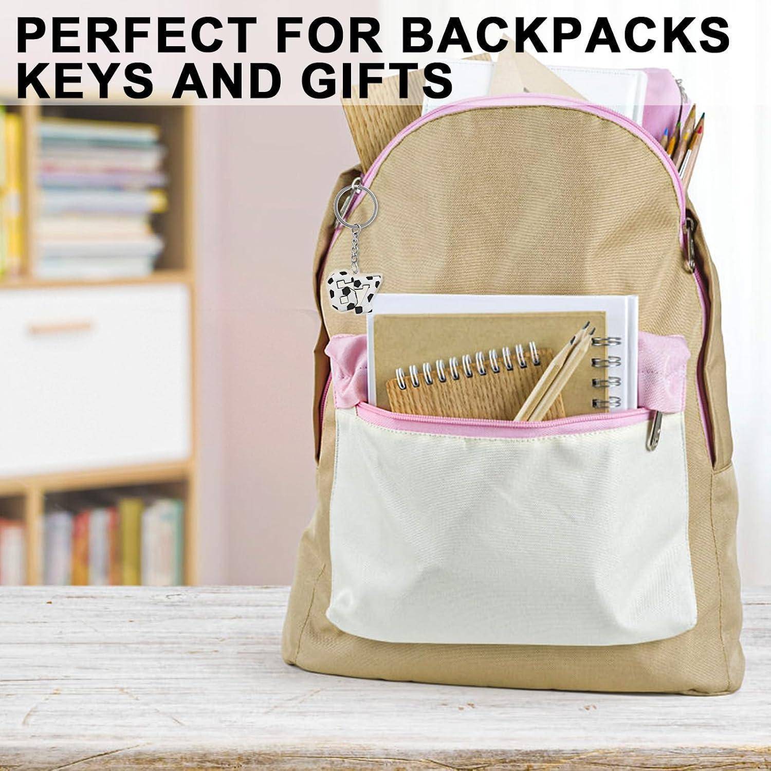 Beige Rucksack mit rosa Besätzen und Vortasche auf einem Tisch, als Geschenkartikel für Rucksäcke, Schlüssel und Geschenke dargestellt.