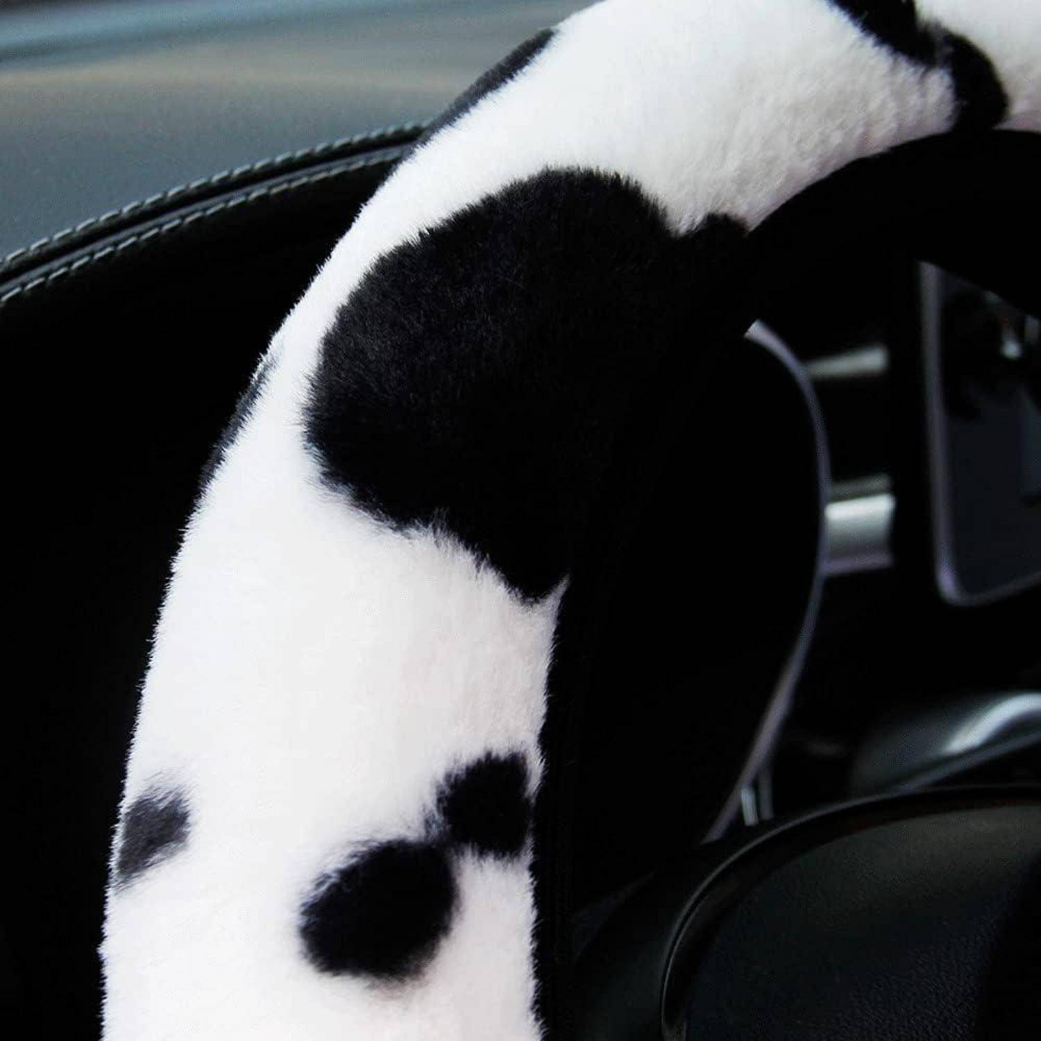 Nahaufnahme einer schwarz-weißen gepunkteten Lenkradbezug auf einem Autolenkrad.