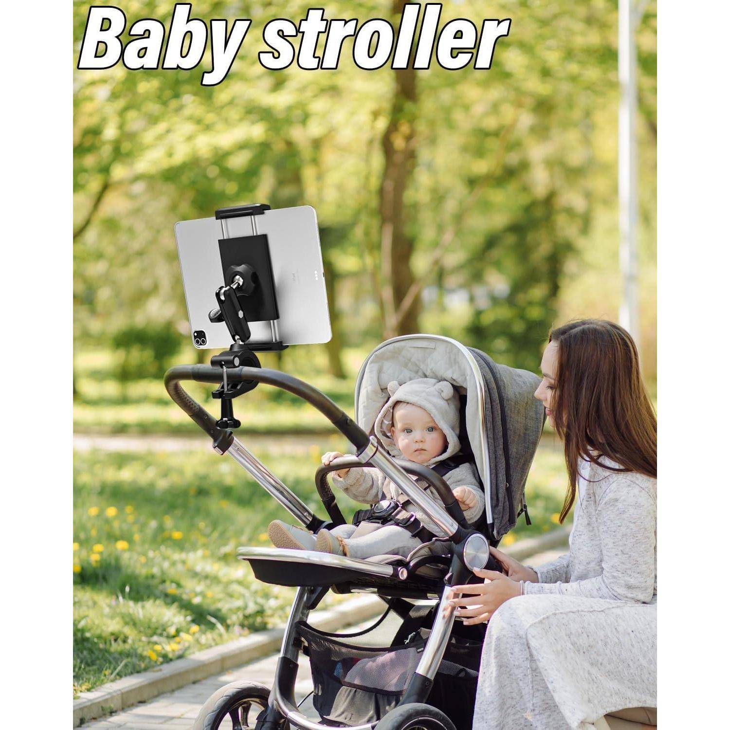 Frau, die einen Kinderwagen in einem Park schiebt, während ein Baby in einem angebrachten Tablet- oder Telefonhalter sitzt und diesen anschaut.
