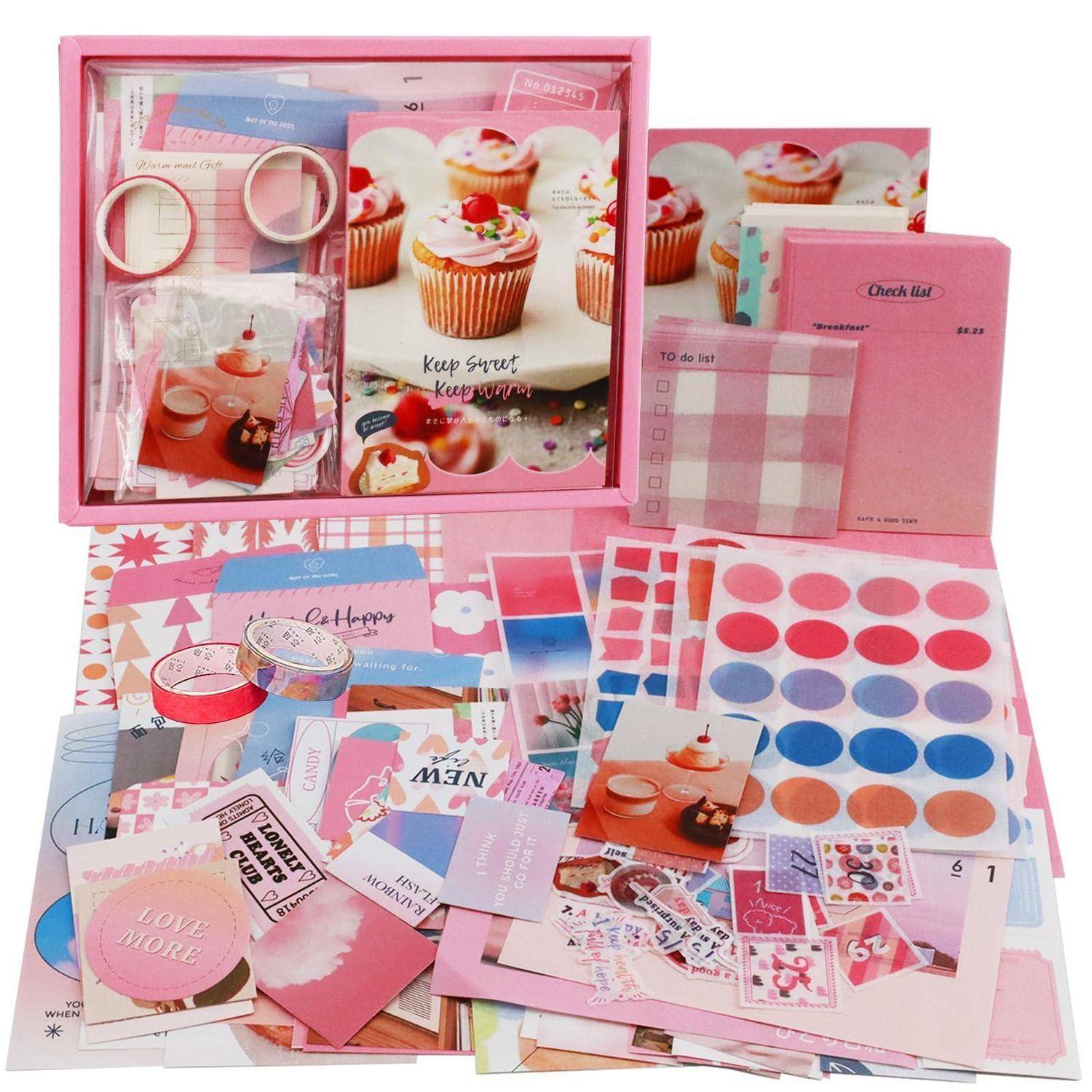 Rosa Schreibwaren- und Scrapbooking-Set mit Cupcake-Design-Notizbuch, Checklisten-Notizblock, Notizblättern, Aufklebern, Washi-Tape, Umschlägen und Dekorationspapier, arrangiert in einer Box.