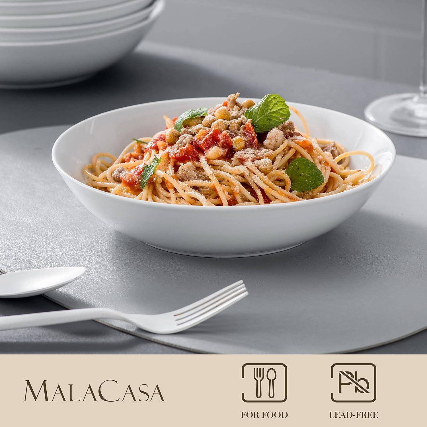 Eine Schüssel Spaghetti mit Tomatensauce, geriebener Käse und Basilikum auf einem grauen Tisch, mit Malacasa-Branding und „Für Lebensmittel" und „Bleifrei""-Symbolen darunter.