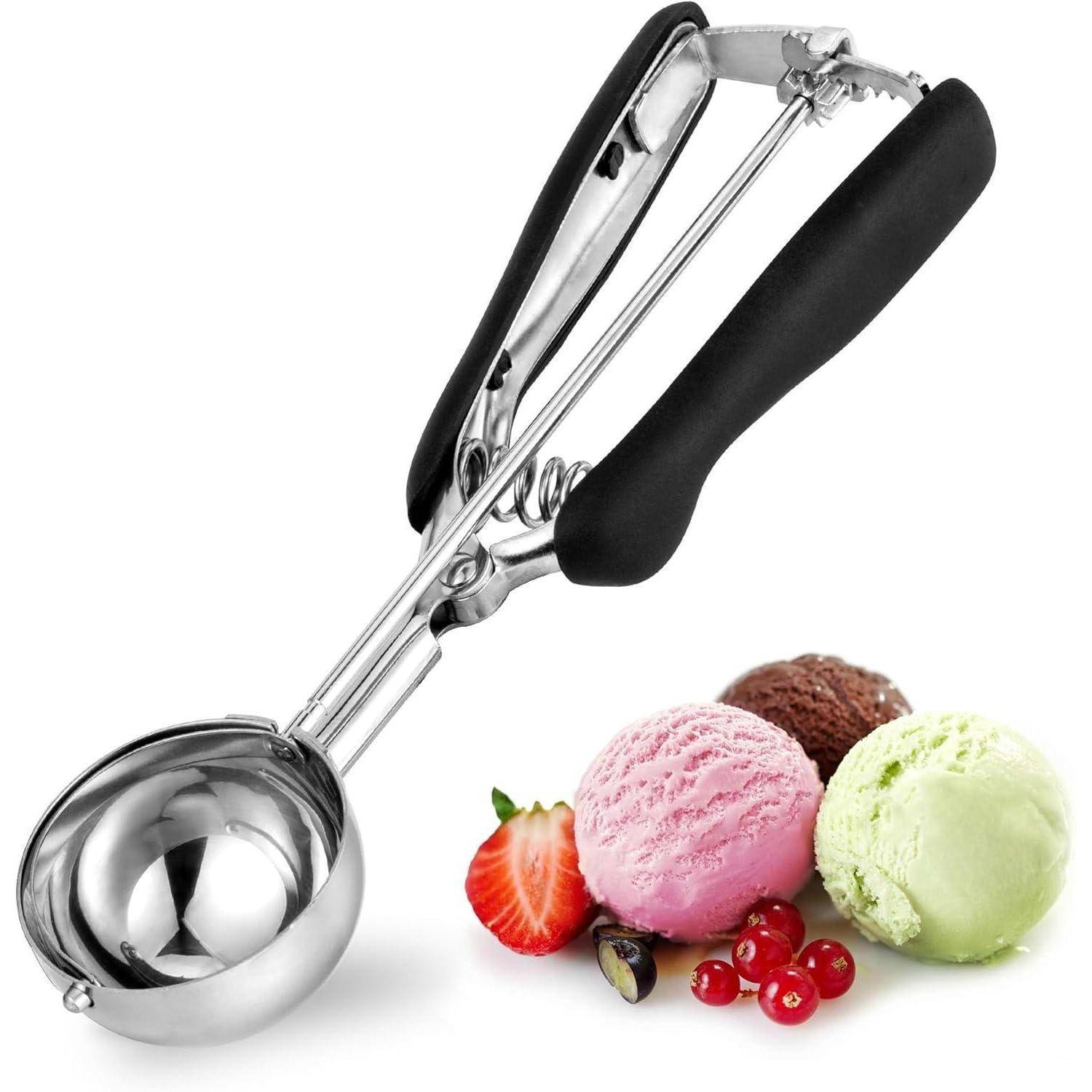 Eislöffel mit schwarzem Griff neben Portionen von rosa, grünem und Schokoladeneiscreme, einer Erdbeerscheibe und roten Johannisbeeren auf weißem Hintergrund.