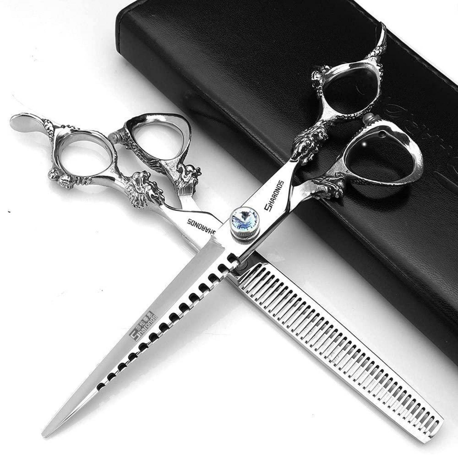 Zwei verzierte Silber-Haarschneidescheren, übereinander gekreuzt, ruhen auf einem Kamm, der auf einem schwarzen Etui liegt.