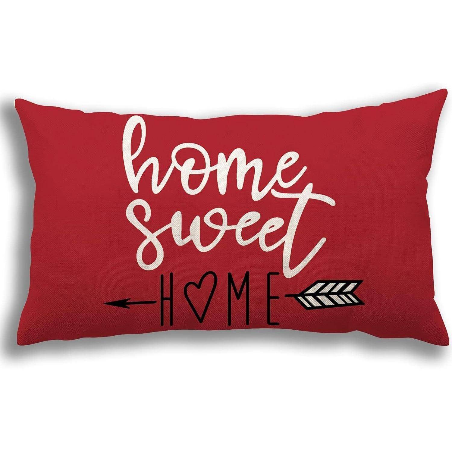Rotes dekoratives Zierkissen mit weißer 'home sweet'-Schrift über 'HOME' und einem Pfeil- und Herzdesign.