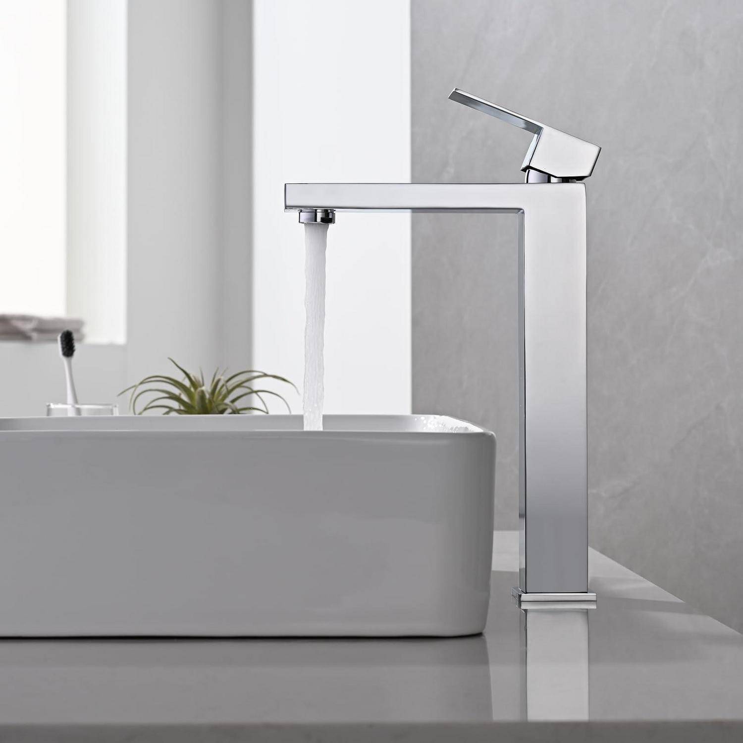 Wasser fließt aus einem modernen Chrom-Badezimmerhahn in ein weißes Aufsatzwaschbecken auf einer Arbeitsplatte.