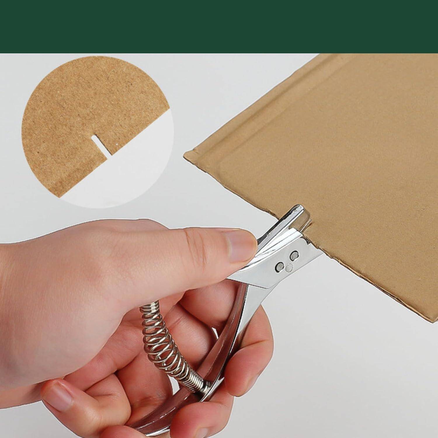 Hand verwendet einen federbelasteten Umschlagöffner zum Aufschlitzen eines braunen Kartonpakets, mit einer Nahaufnahme-Einsatz, die die Klingenspitze zeigt.