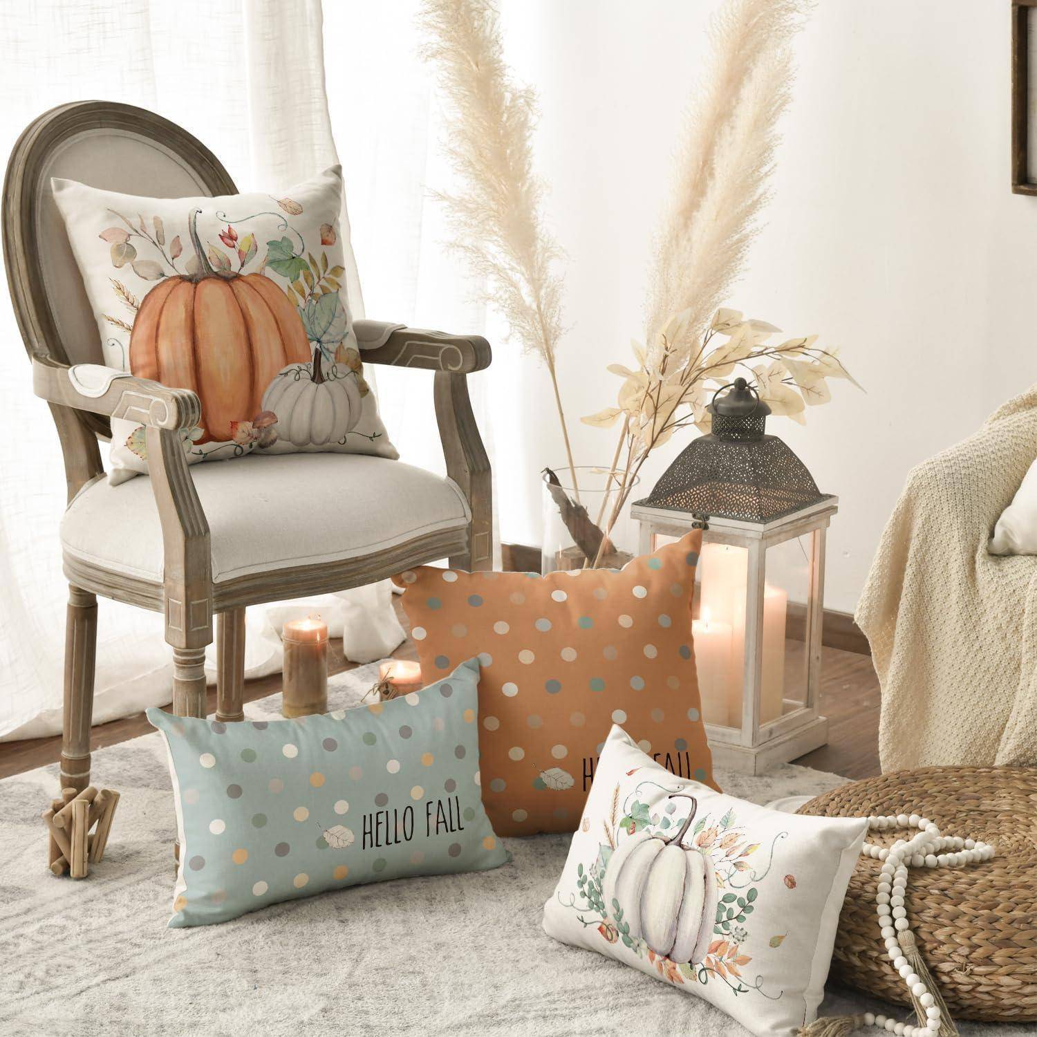 Gemütliche Herbst-Wohnzimmereinrichtung mit Kürbiskissen, einem gepolsterten Sessel, einer Laterne, Kerzen, Pampasgras und einem gewebten Pouf auf einem Teppich.