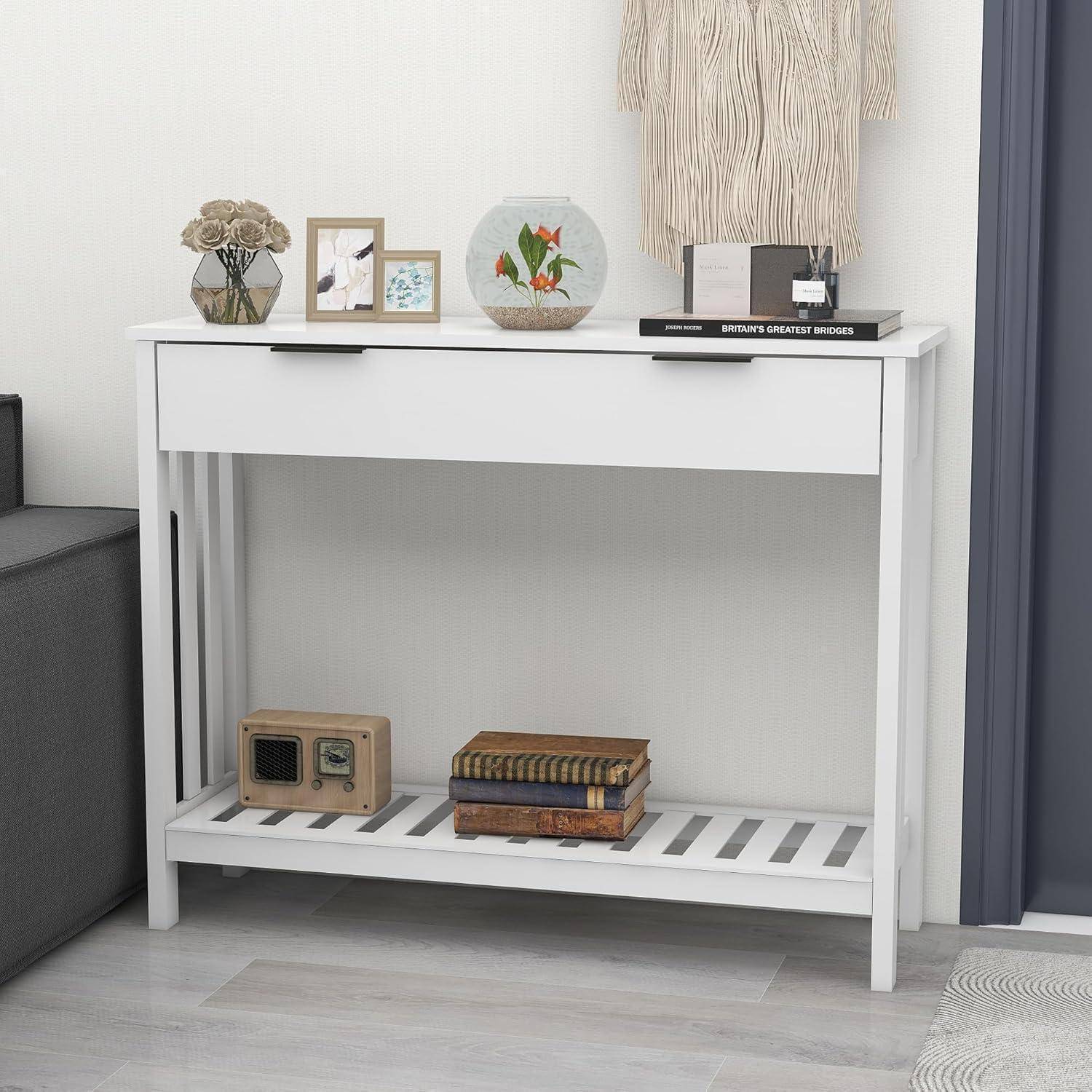Weißer Konsolentisch mit einer Schublade und untere Ablage, dekoriert mit gerahmten Fotos, Vase, dekorativem Teller, Büchern und kleinem Radio in einem modernen Zimmer.