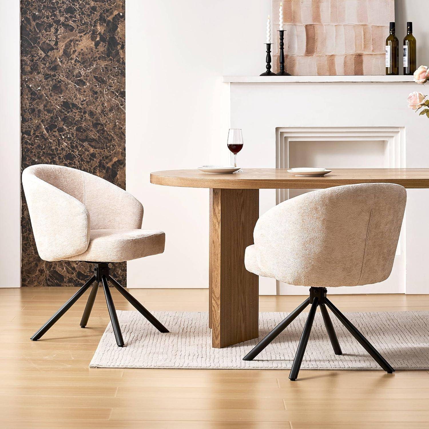 Modernes Esszimmer mit zwei beigen Drehstühlen um einen runden Holztisch, mit einem Weinglas und Tellern auf dem Tisch