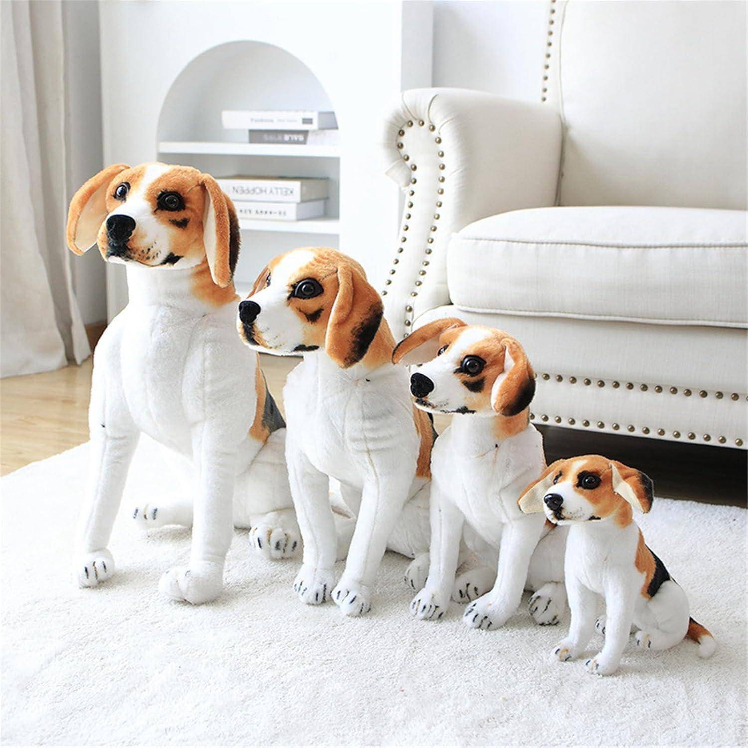 Vier Beagle-förmige Figürchen in abnehmender Größe sitzen auf einem weißen Teppich in einem hellen Wohnzimmer neben einem weißen Sofa.