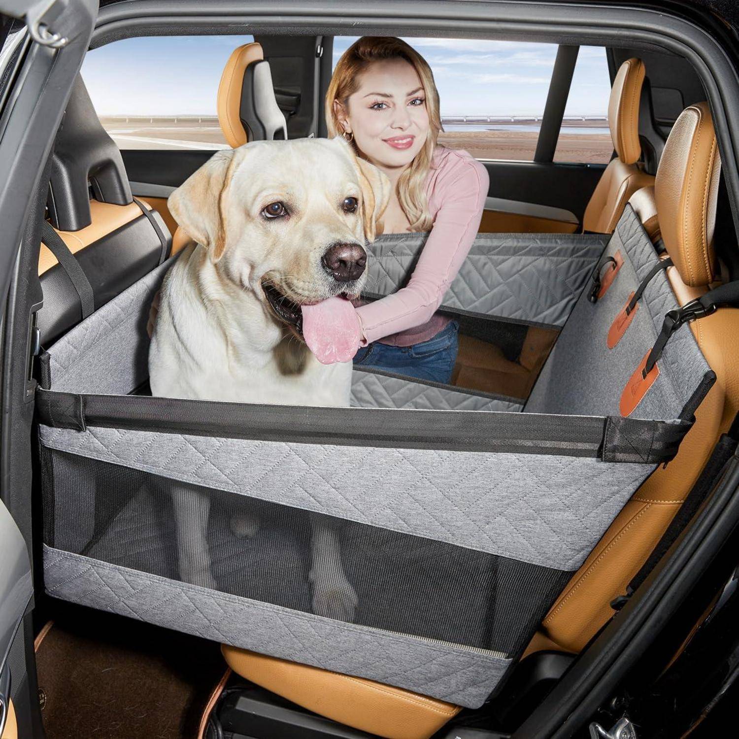 Frau mit einem großen Labrador auf der Rückbank eines Autos, getrennt durch eine graue Tierschutzbarriere für sichere Reisen.