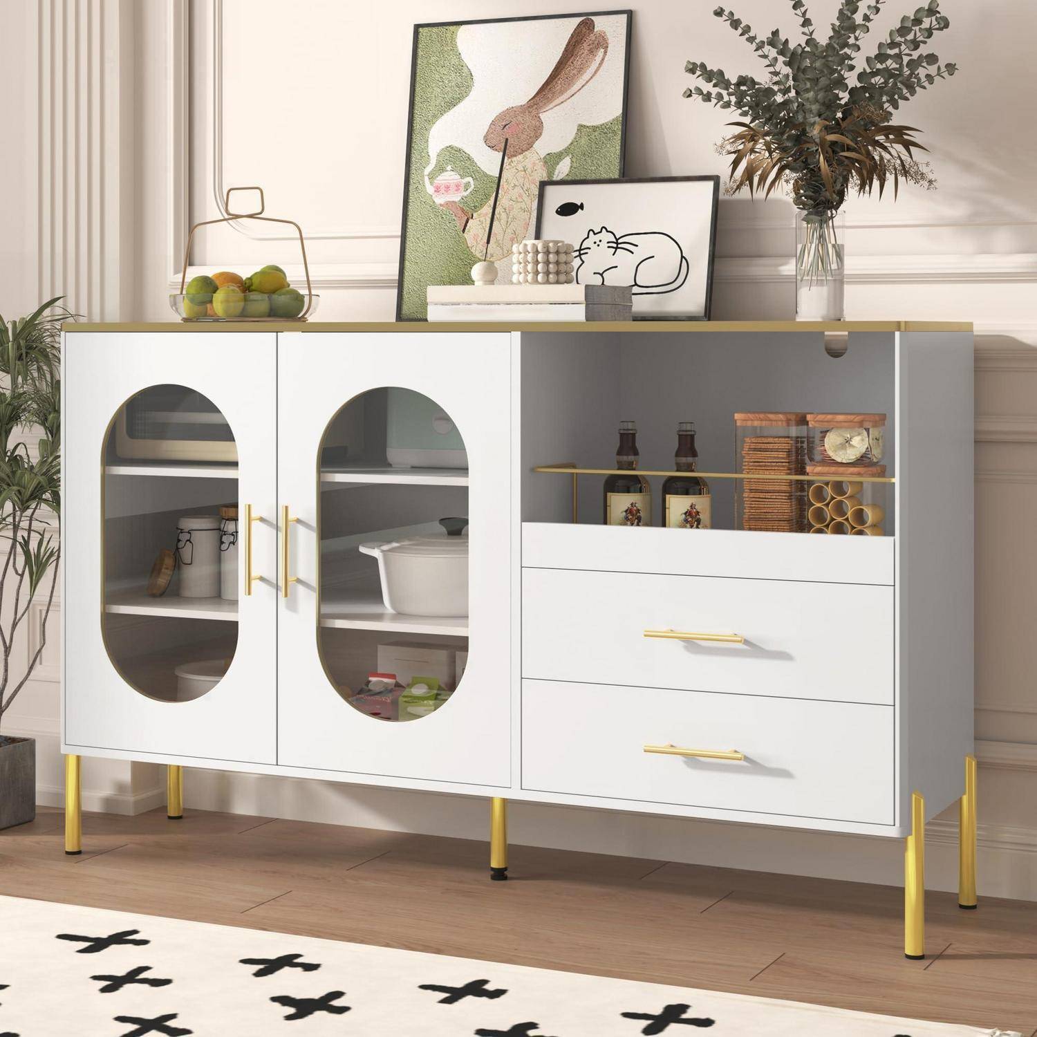 Modernes weißes Sideboard mit ovalen Glastüren und Schubladen, bestückt mit Rahmenbildern, Pflanze und Dekoration in einem hellen Raum.