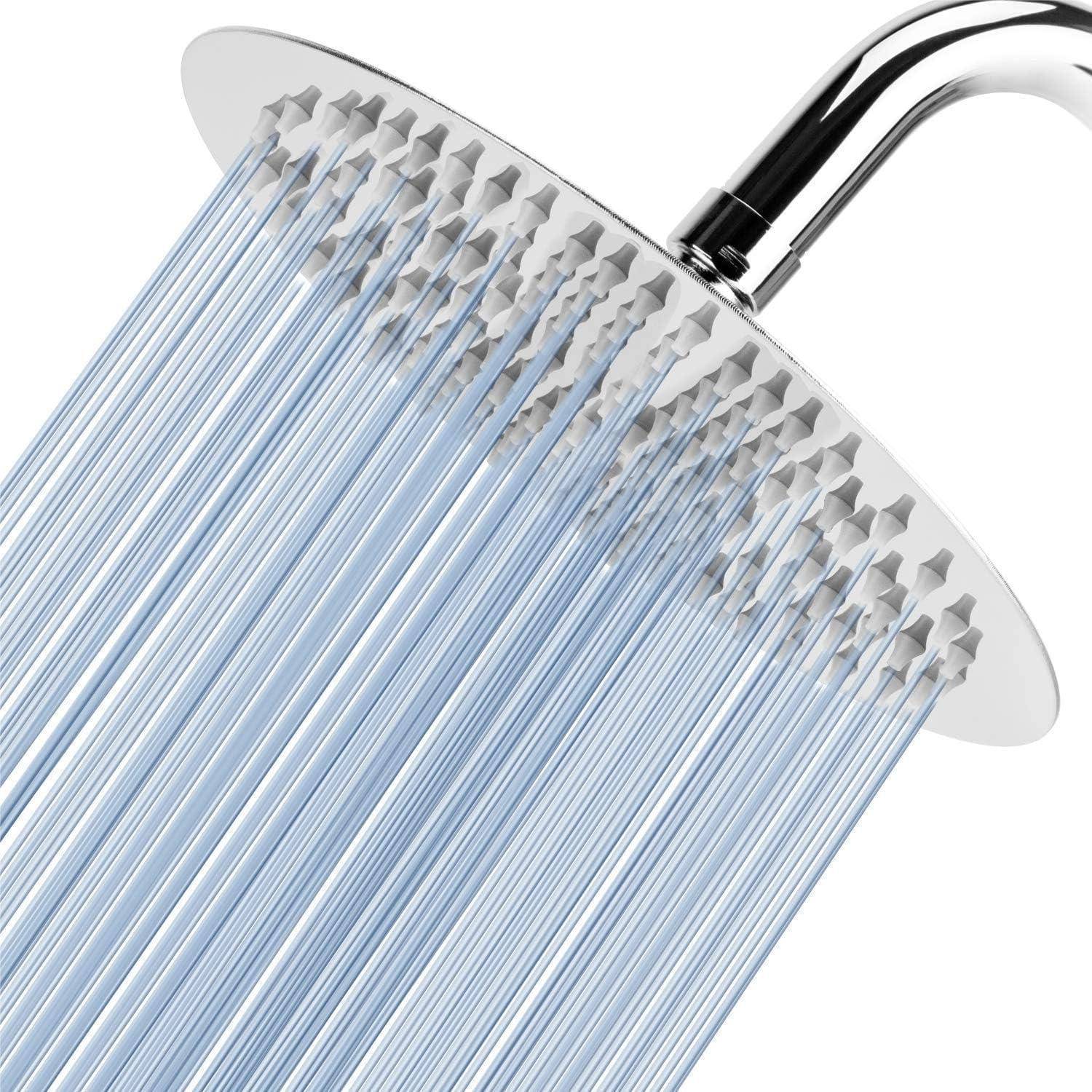 Nahaufnahme eines verchromten Duschkopfes, der viele dünne Wasserstrahlen gegen einen weißen Hintergrund sprüht.