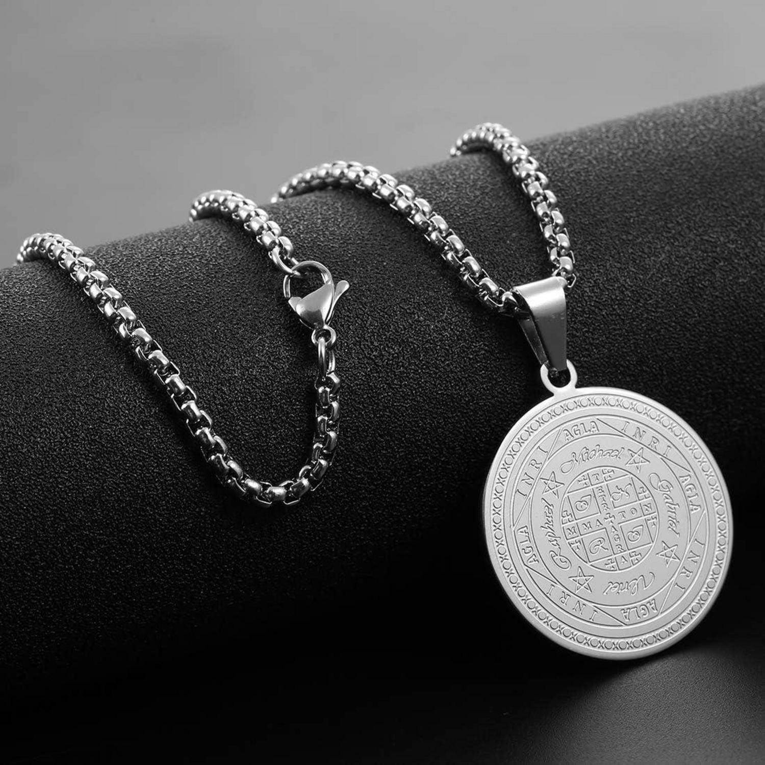 Silberne Gliederkette mit rundem graviertem Anhänger auf einem schwarzen Ständer präsentiert