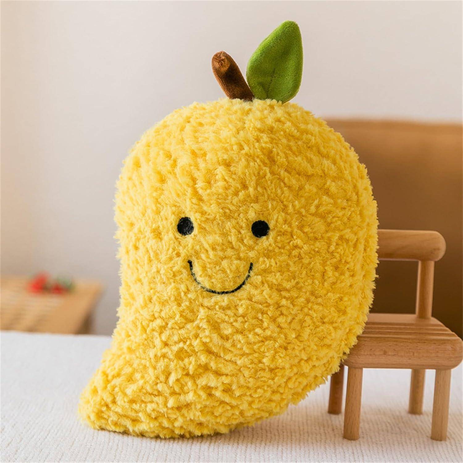 Gelbes weiches Obst-förmiges Kissen mit lachendem Gesicht und grünem Blatt, gelehnt an einen kleinen Holzstuhl.