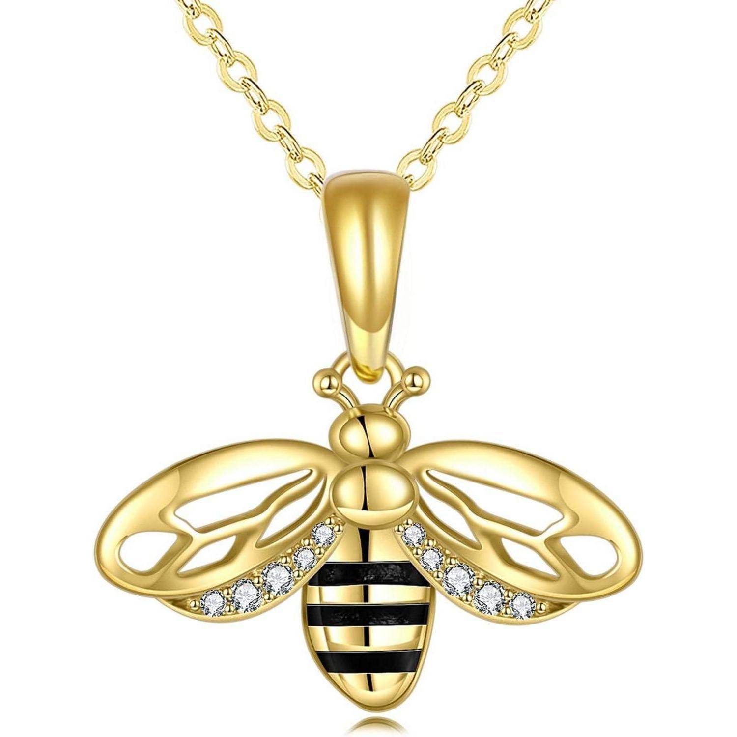 Goldene Bienenhängerkette mit diamantbesetzten Flügeln an einer Kette, vor einem einfachen weißen Hintergrund abgebildet.