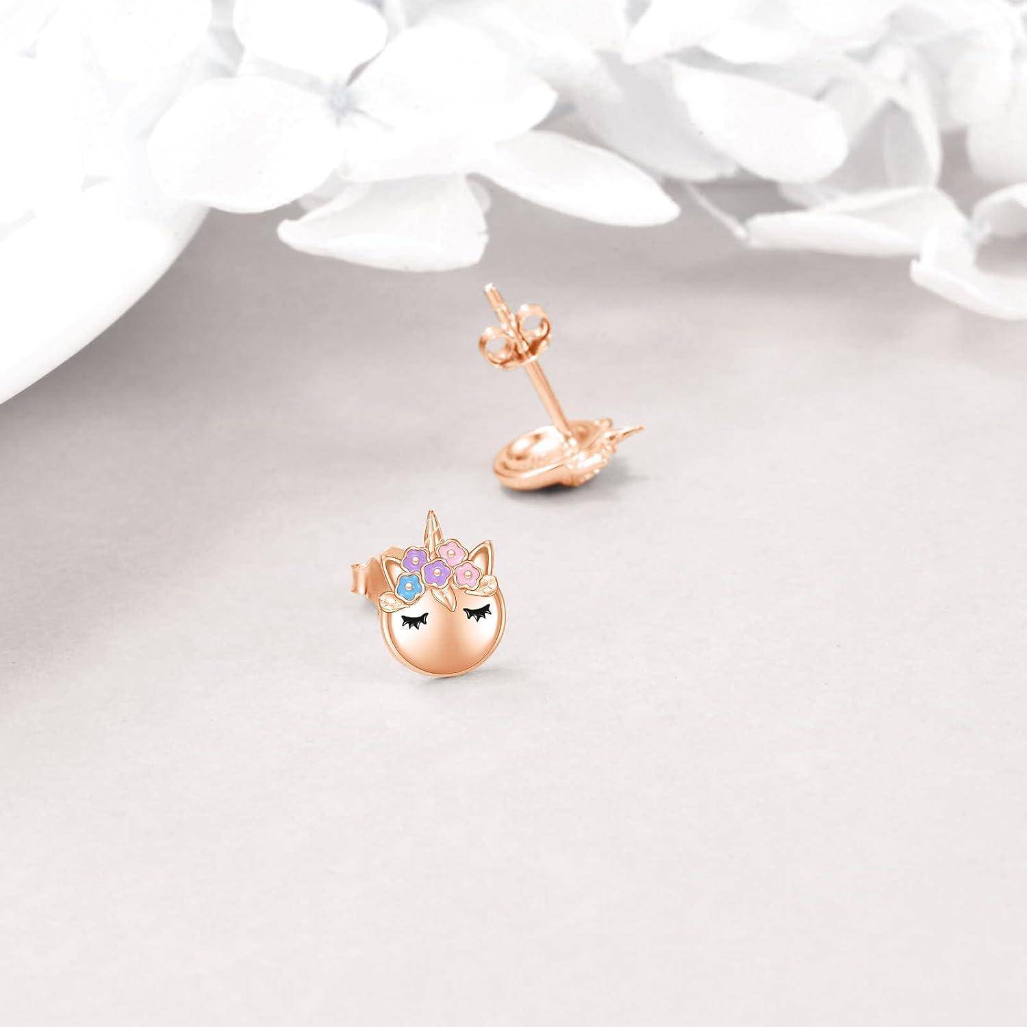 Roségold-Einhorn-Stecker-Ohrringe, einer frontal mit einem pastellfarbenen Edelstein-und-Blumen-Einhorngesicht gezeigt, der andere angewinkelt, um die Stift- und Rückseite zu zeigen.