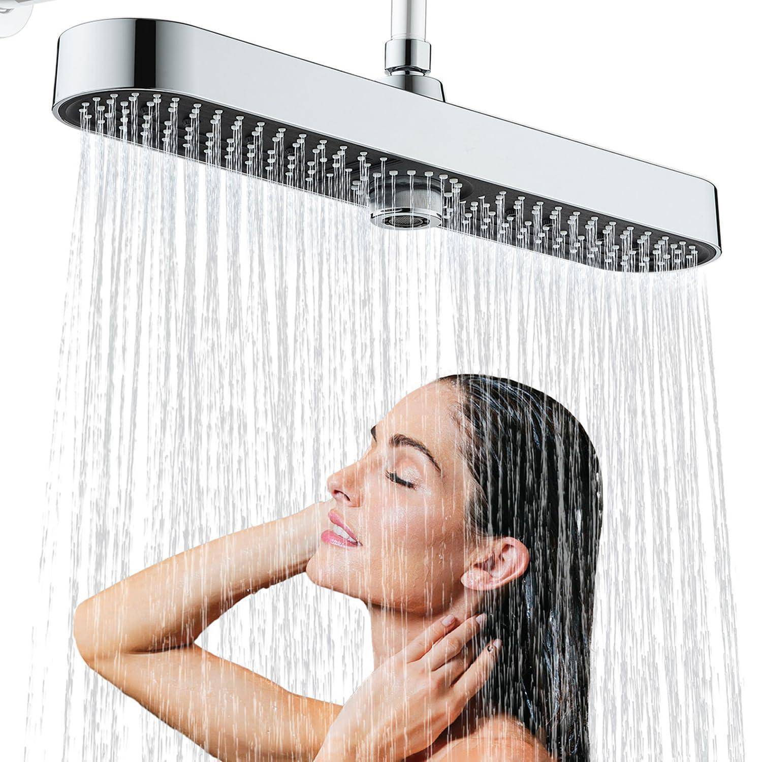 Frau, die sich unter einem Regenduschkopf entspannt, während Wasser über ihr in einem Badezimmer herabströmt.