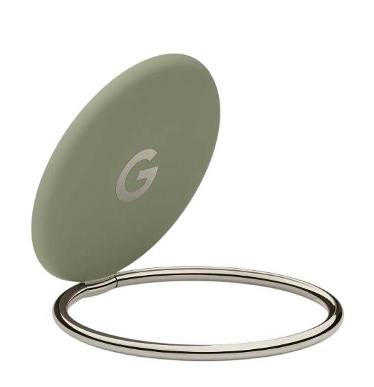 Ein kleines, olivgrünes, kreisförmiges Google-Gerät auf einem silbernen Ringständer, gezeigt auf weißem Hintergrund.