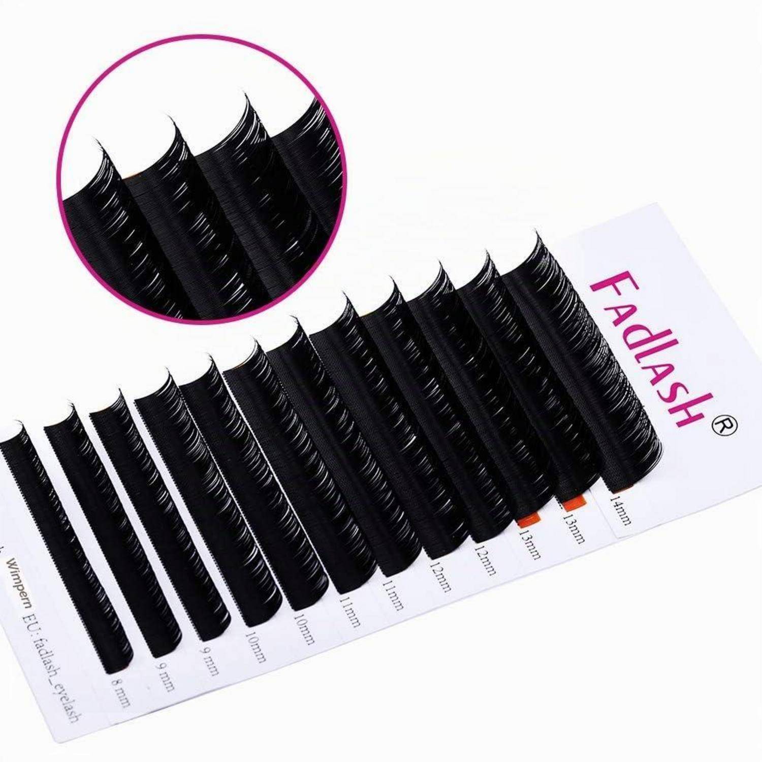 Ein Set schwarzer falscher Wimpernverlängerungen, nach Länge sortiert auf einer weißen Fadlash-Displaykarte angeordnet, mit einem kreisförmigen Detailausschnitt, der die Wimpernstruktur zeigt.
