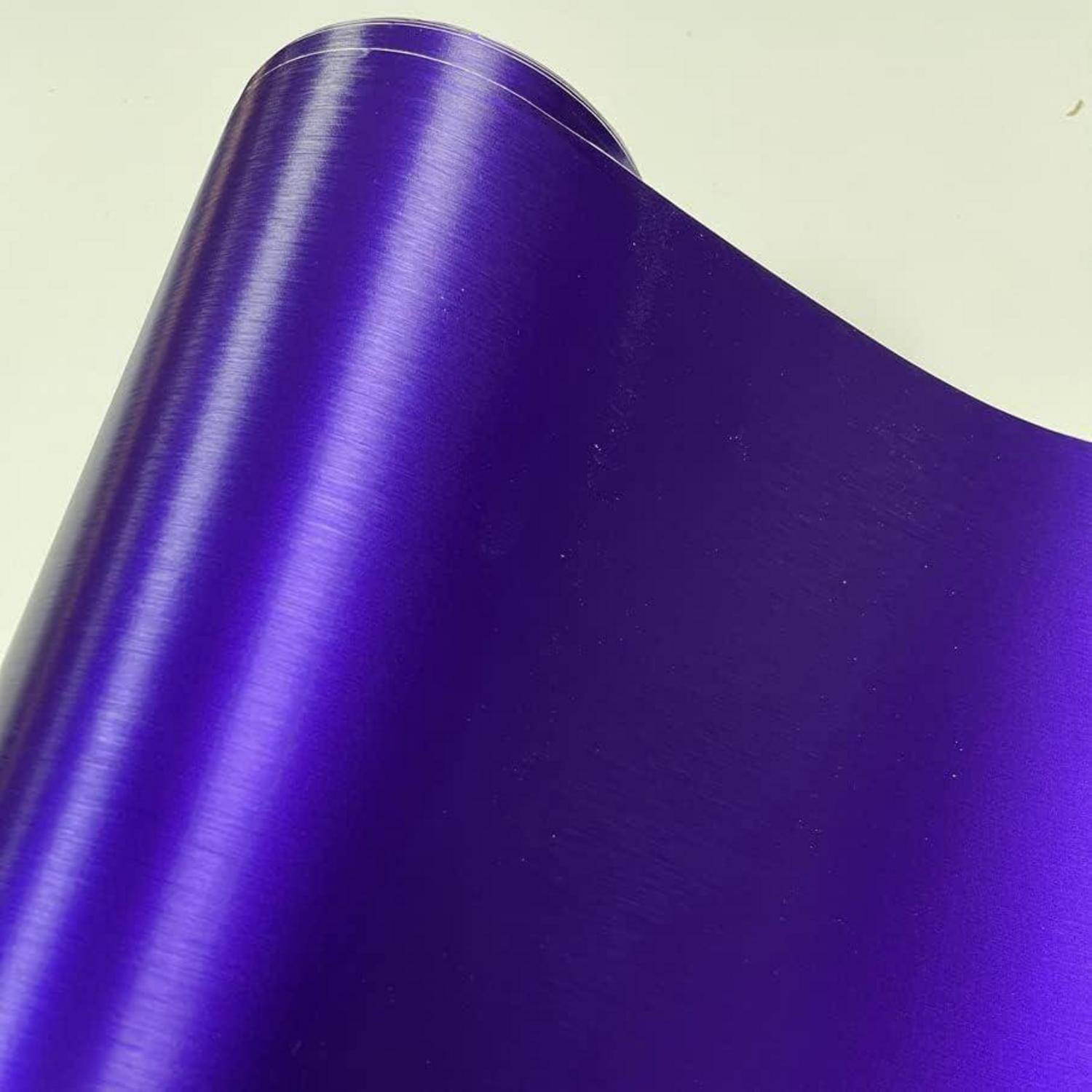 Nahaufnahme einer aufgerollten Folie aus glänzendem violettem Metallmaterial vor hellem Hintergrund.