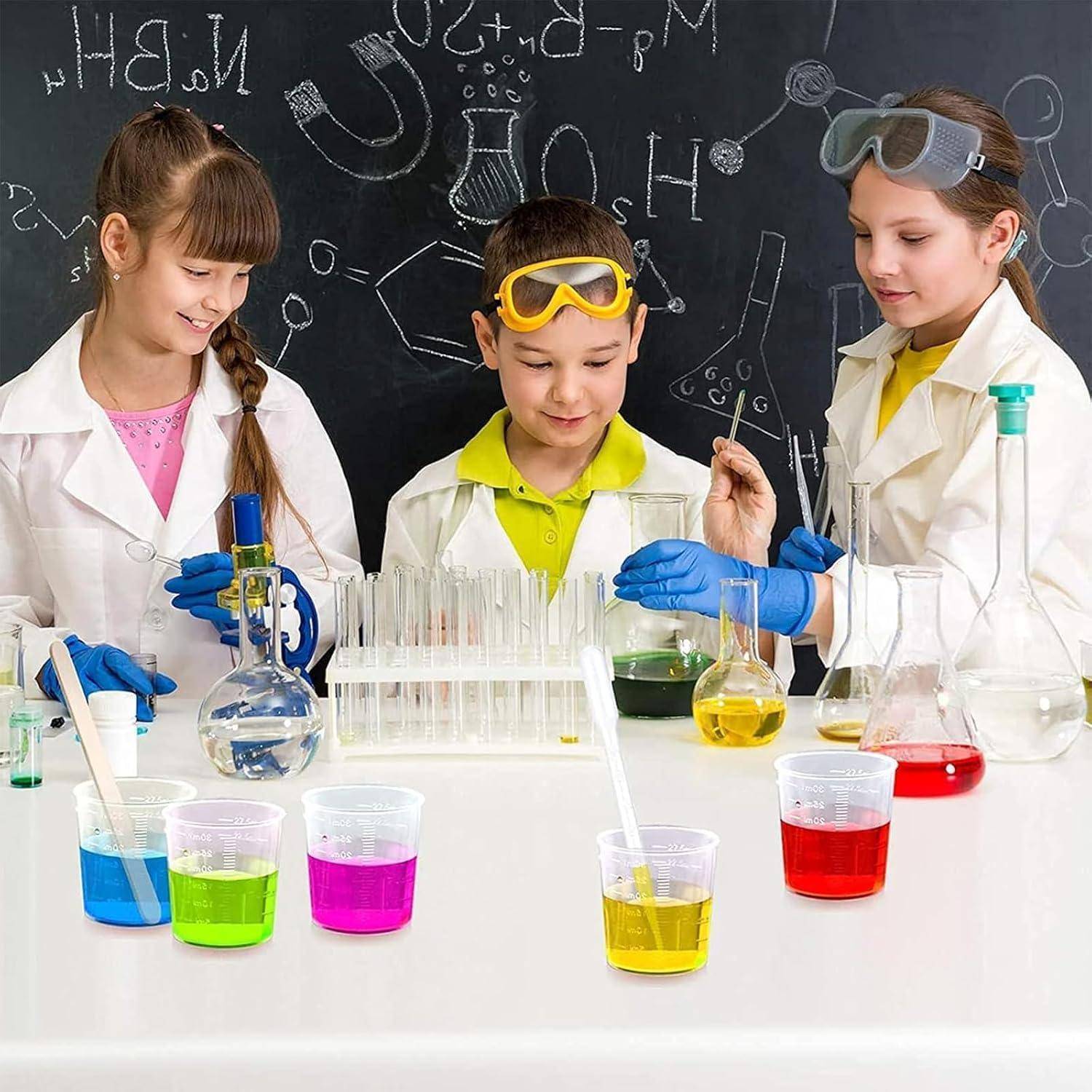 Drei Kinder in Laborkitteln und Schutzbrille führen ein wissenschaftliches Experiment mit Reagenzgläsern und farbigen Flüssigkeiten in einem Klassenzimmer-Labor durch.