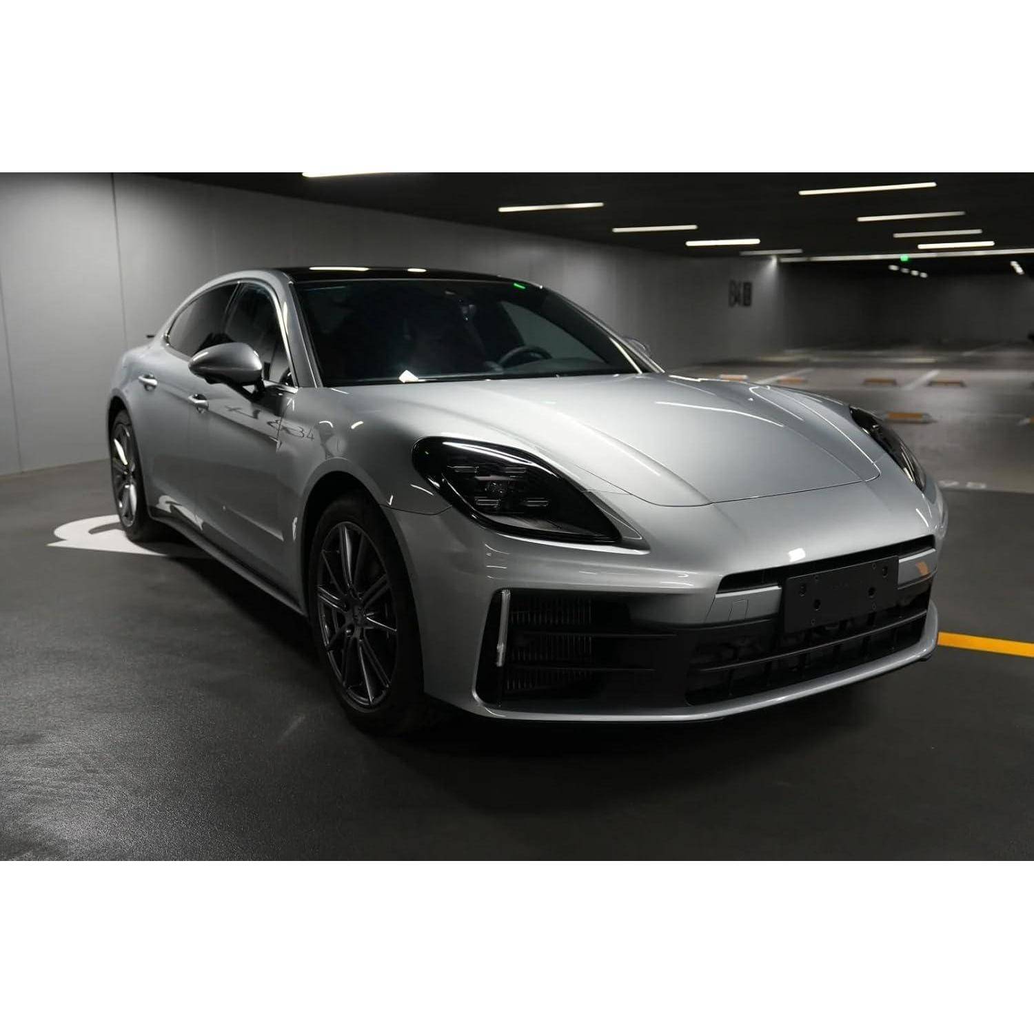 Silber-farbene Sportlimousine in einem düsteren Innenparkhaus geparkt, von vorne links fotografiert.