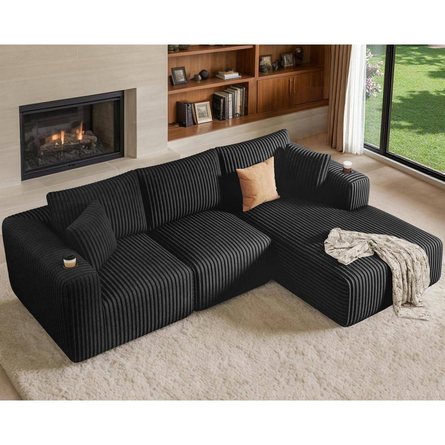 Schwarz gestreiftes Ecksofa mit Kissen und Wurfdecke in einem modernen Wohnzimmer neben einem Kamin, Bücherregal und großem Fenster.