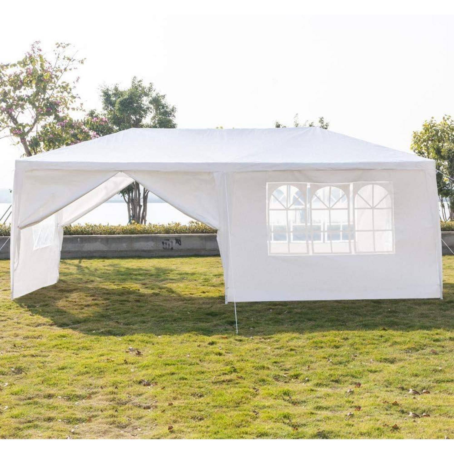 Weißes Außenevent-Zelt mit offener Frontlasche und belichtetem Seitenpanel auf Gras in einem sonnigen Park aufgebaut.