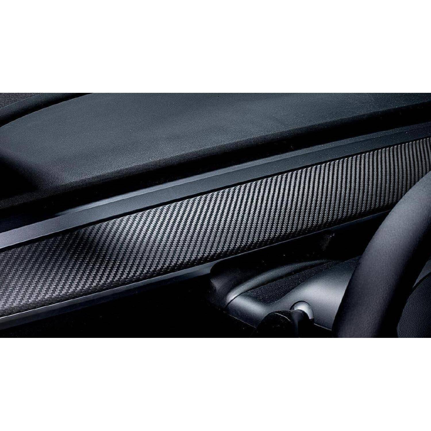Nahaufnahme einer Autoinnenraum-Armaturenbrett-Verkleidung mit Kohlefaser-Muster und einem sichtbaren Teil des Lenkrads.