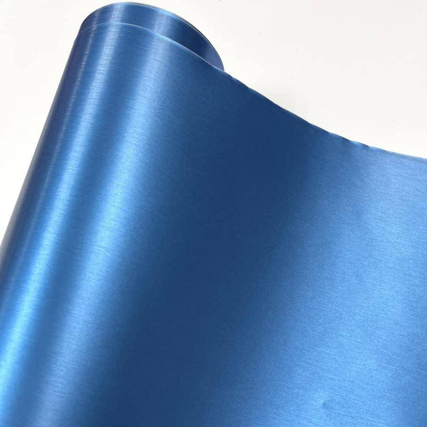 Nahaufnahme eines glänzenden blauen Metallblatts oder einer Rolle, gebogen gegen einen schlichten weißen Hintergrund.